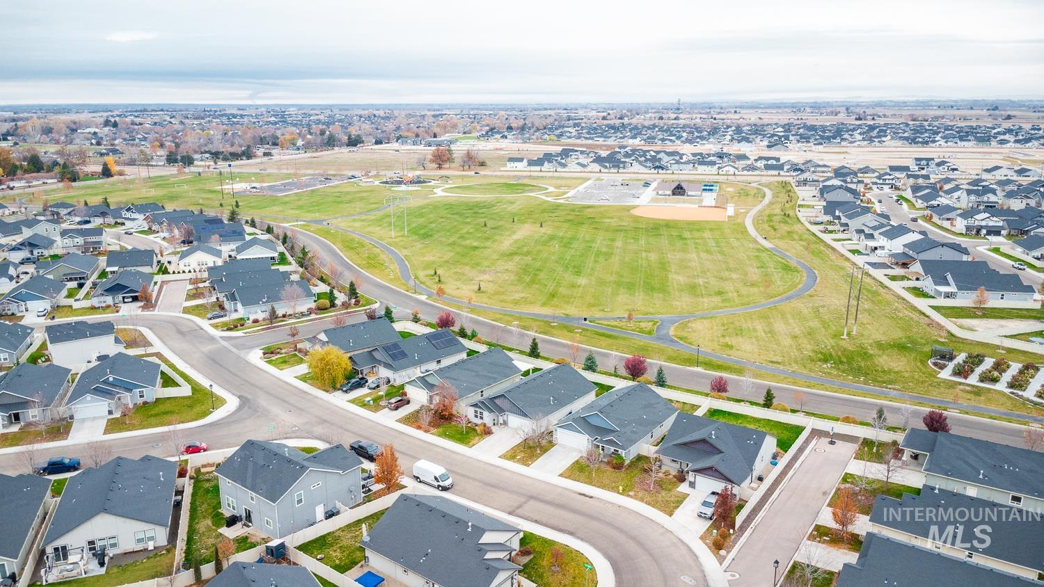 Aerial view of property and surrounding area with nearby suburban area