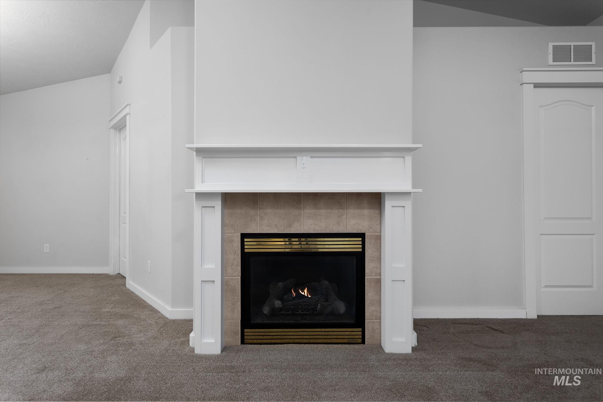 Detailed view of carpet floors and a tiled fireplace
