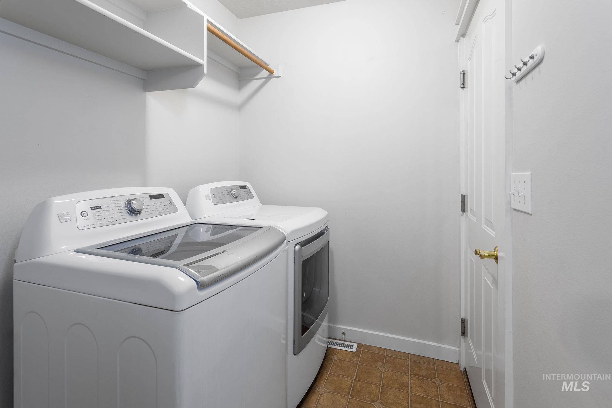 Laundry room featuring washer and clothes dryer and tile patterned floors