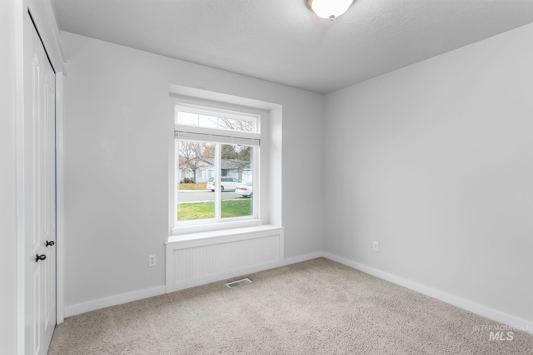 Carpeted empty room featuring baseboards