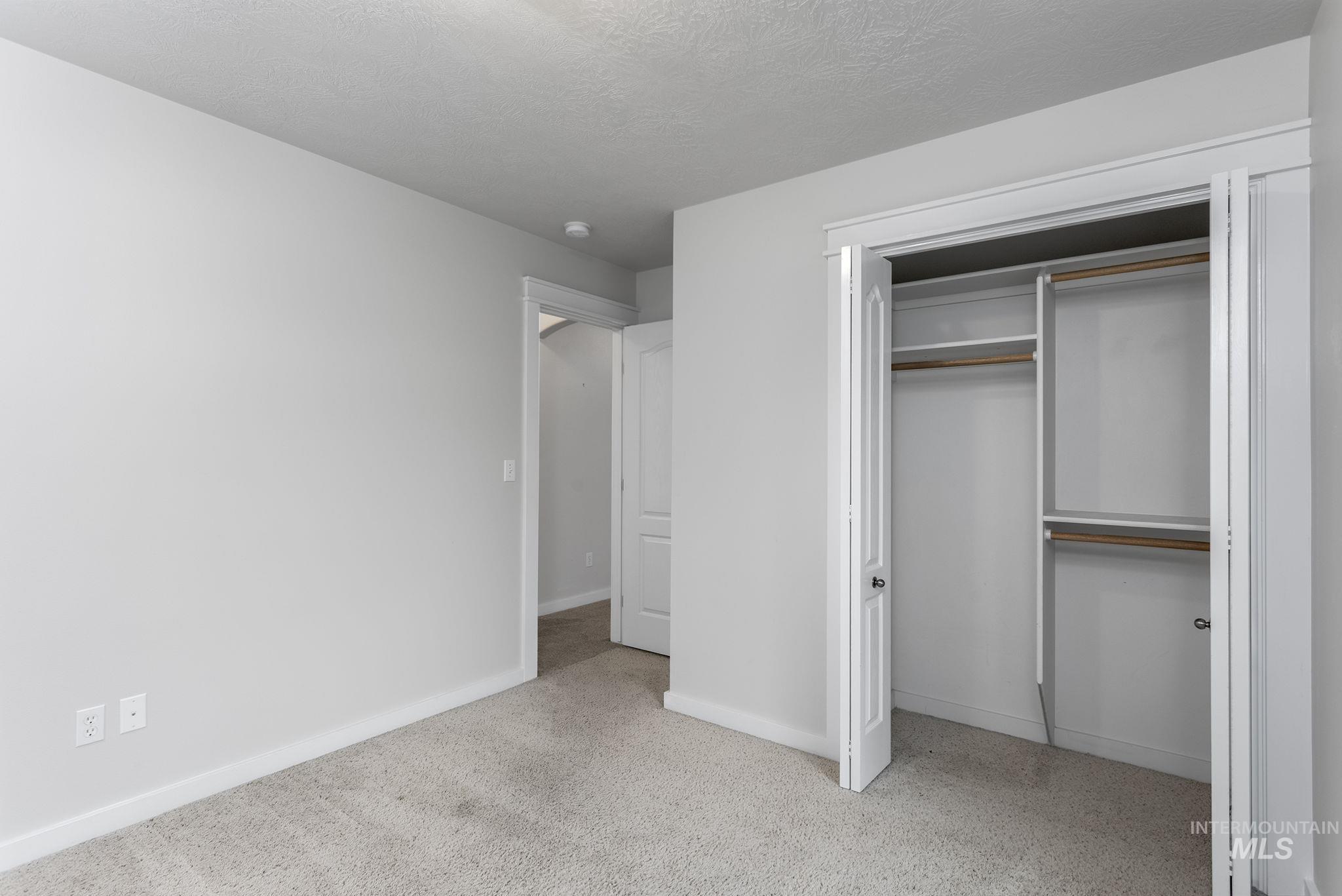 Unfurnished bedroom with a textured ceiling and a closet