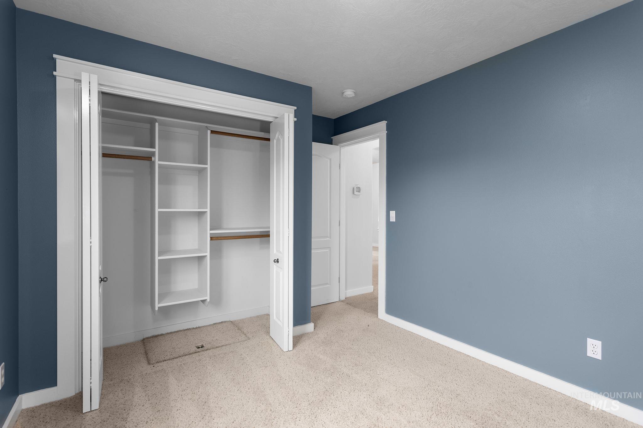 Unfurnished bedroom with light colored carpet and a closet