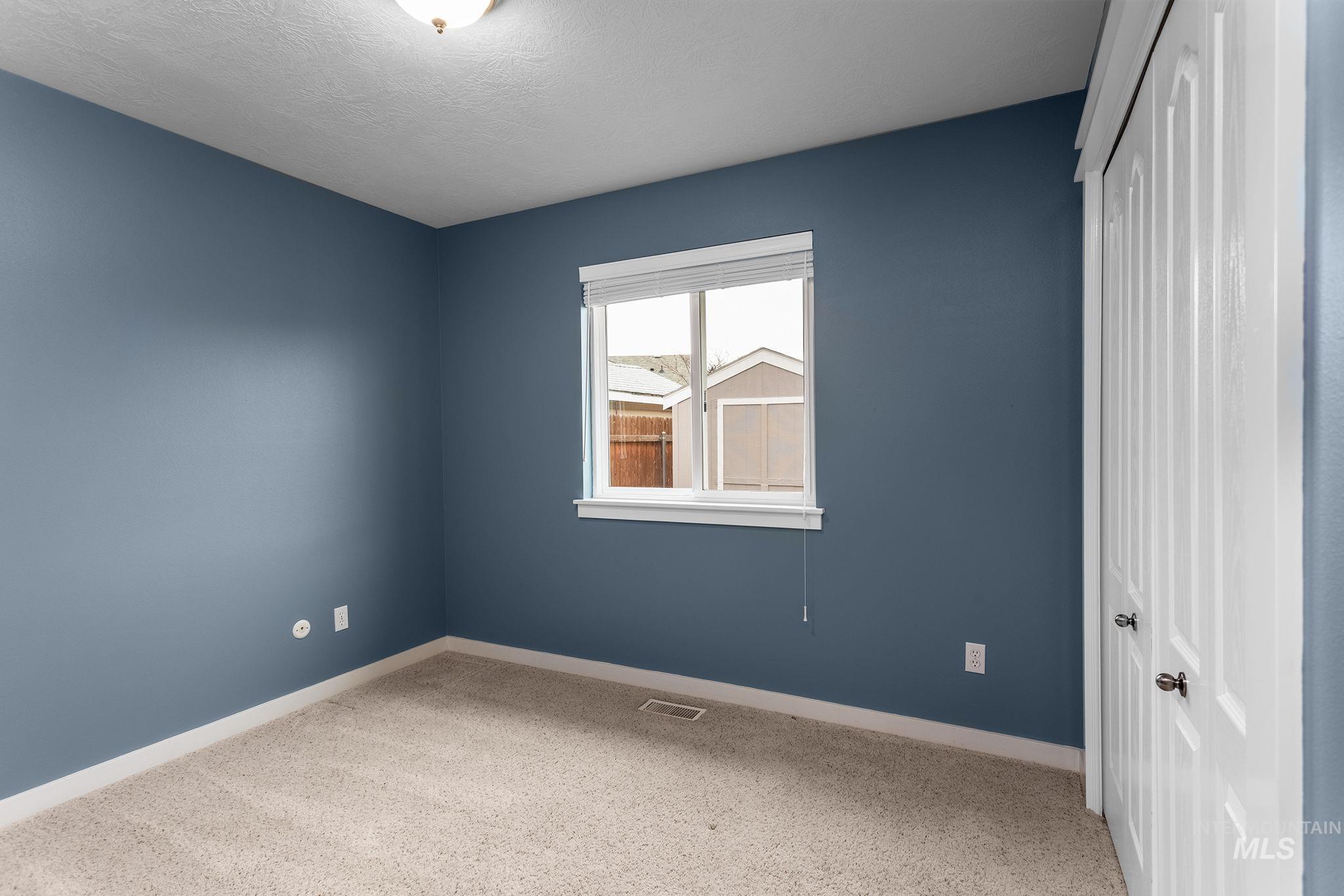 Unfurnished bedroom with light carpet, a closet, and a textured ceiling