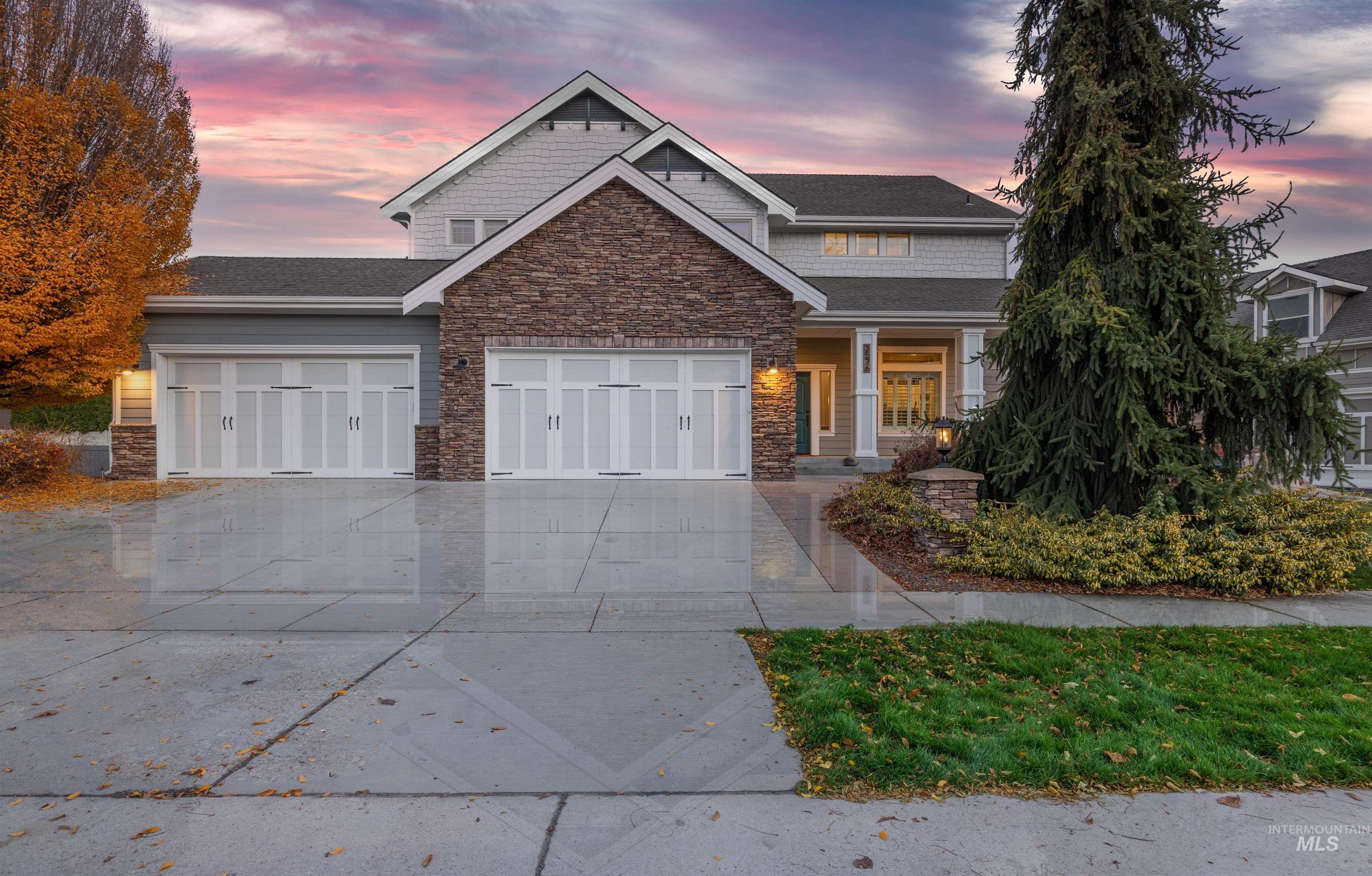 Craftsman-style home with driveway, a porch, a garage, stone siding, and a shingled roof