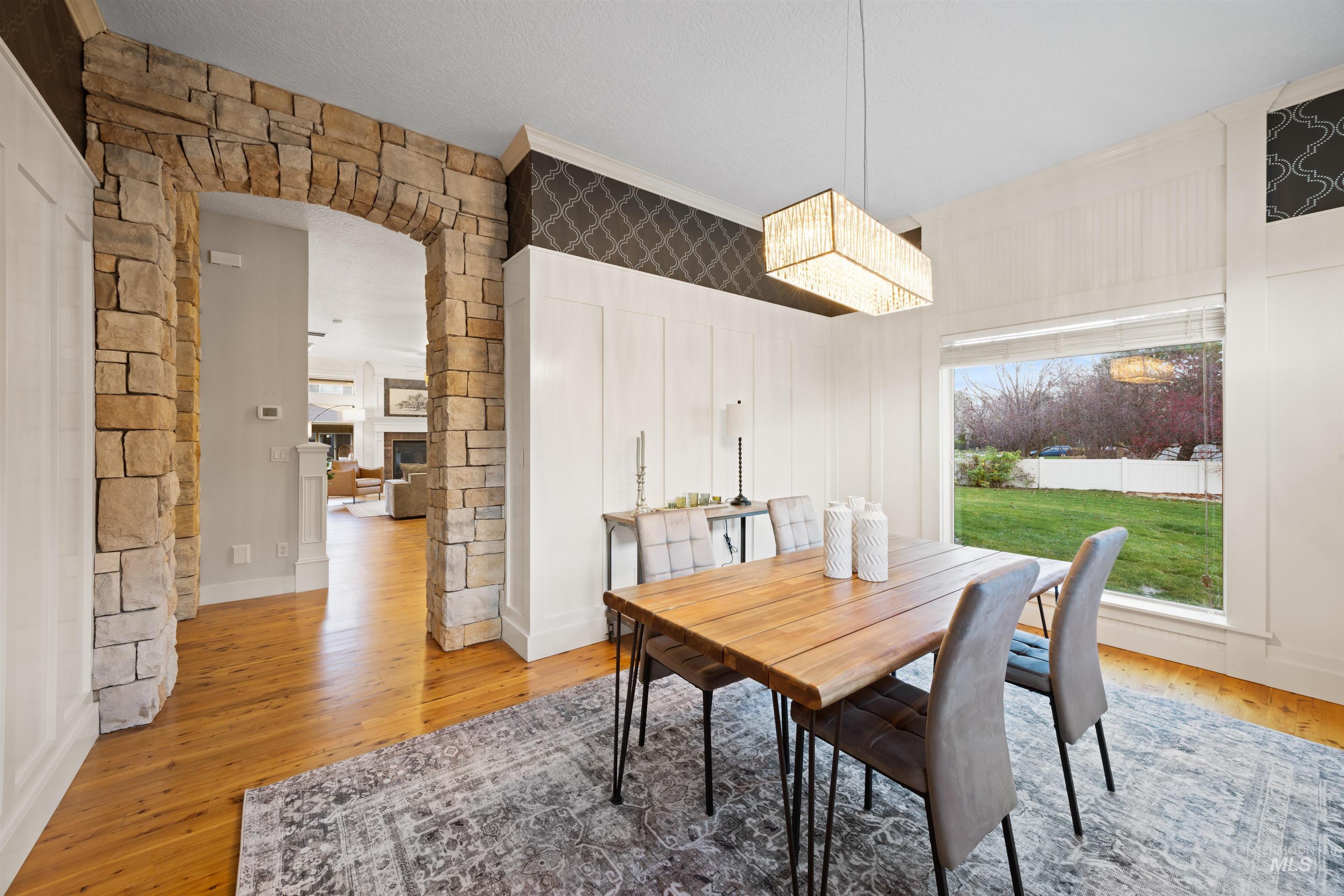 Dining room featuring wood finished floors, arched walkways, and a fireplace