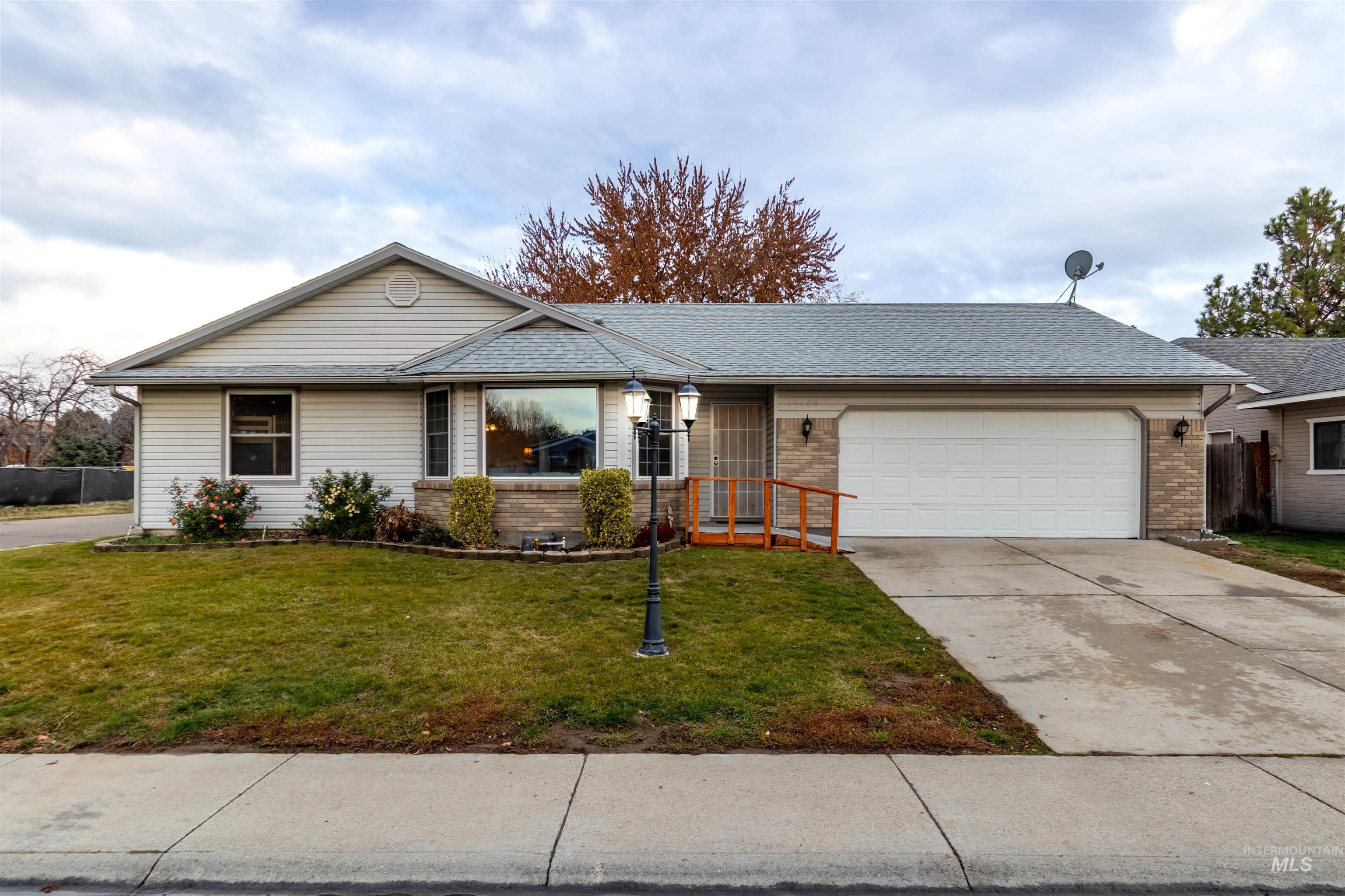 Ranch-style house with brick siding, driveway, an attached garage, and a shingled roof