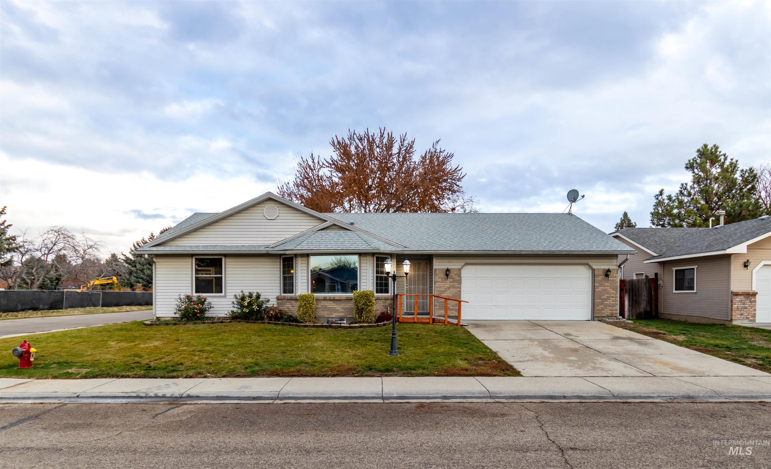 Ranch-style house featuring brick siding, driveway, and an attached garage