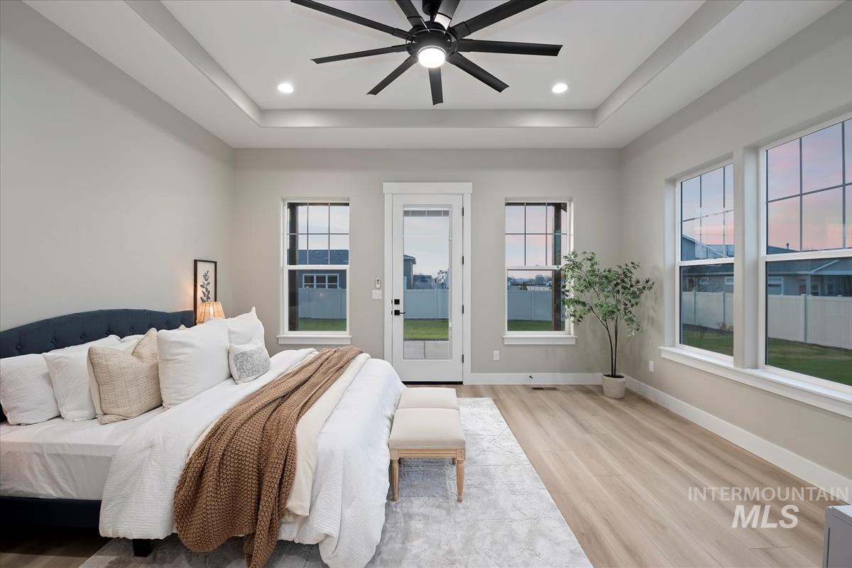 Bedroom featuring light wood-type flooring, ceiling fan, access to outside, multiple windows, and recessed lighting