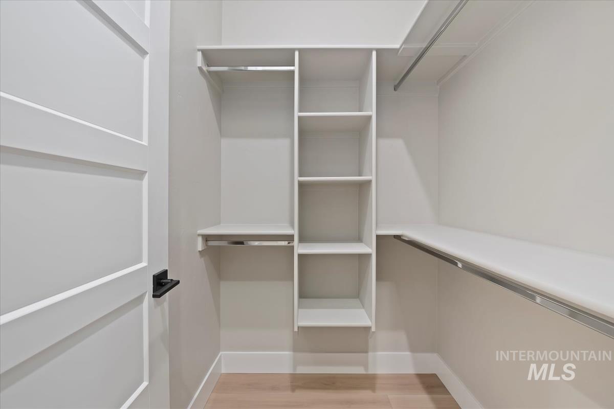 Walk in closet with light wood-style floors