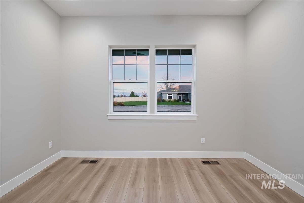 Unfurnished room featuring baseboards and light wood finished floors