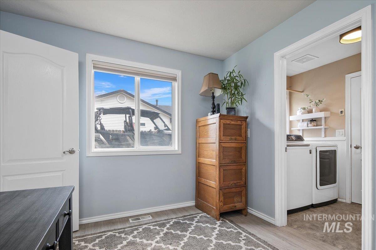 Washroom featuring light wood-style floors and washing machine and clothes dryer