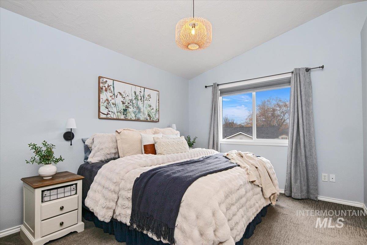 Bedroom featuring vaulted ceiling and carpet flooring