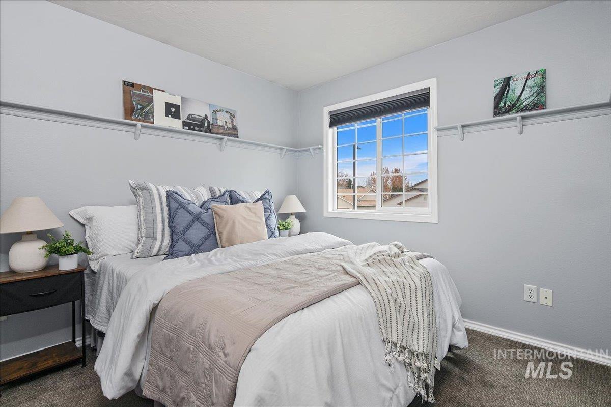 Bedroom with dark colored carpet and baseboards