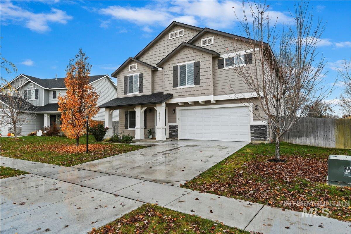 View of front of home with covered porch, driveway, and a garage