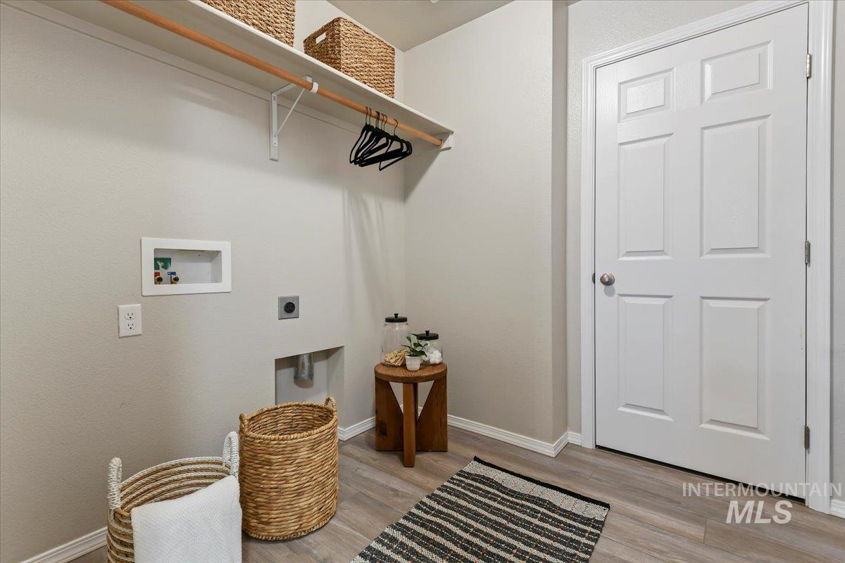 Laundry area featuring light wood-type flooring, electric dryer hookup, and washer hookup