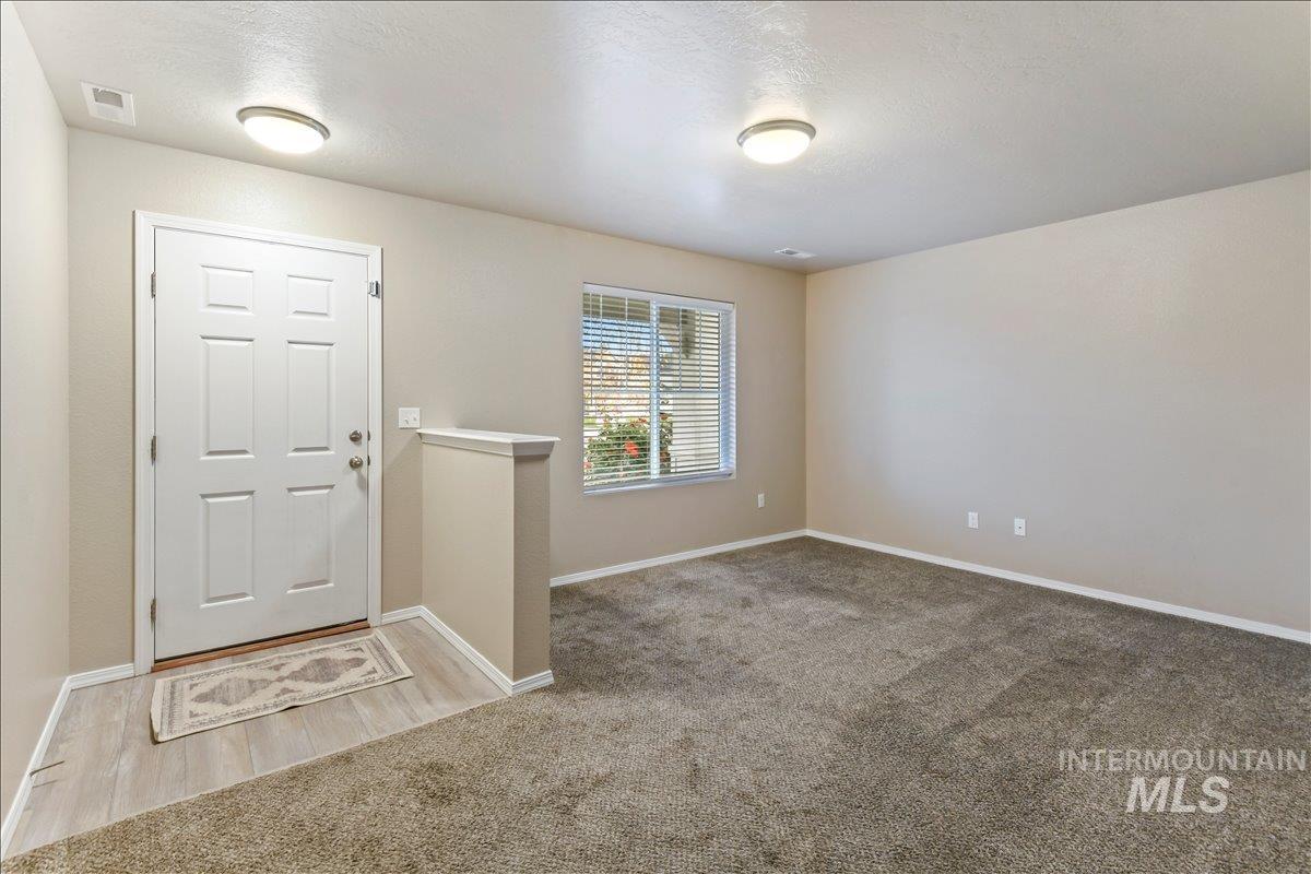 Carpeted entryway with a textured ceiling