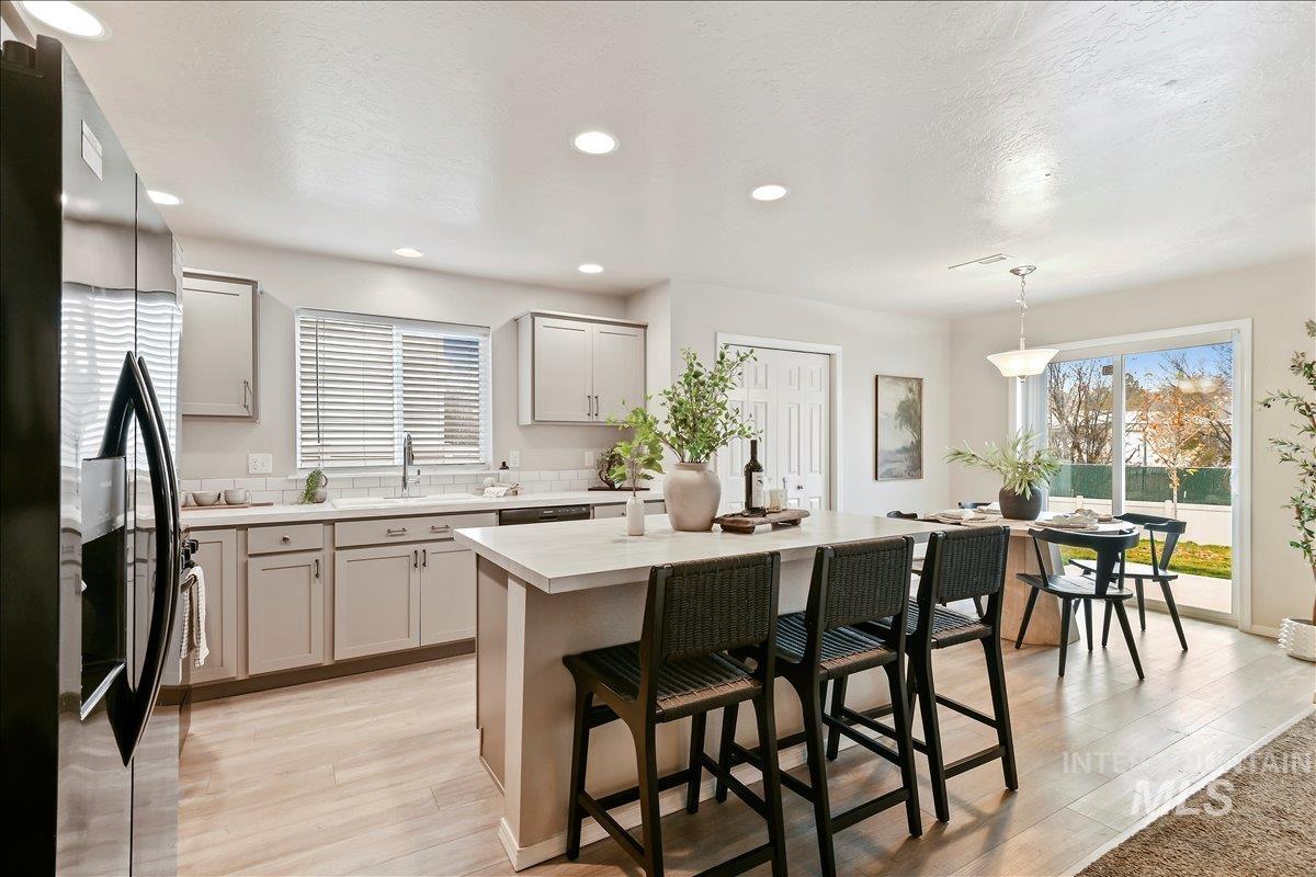 Kitchen featuring, light countertops, decorative light fixtures, and center island