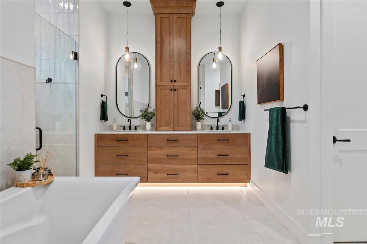 Bathroom with a soaking tub, a stall shower, and double vanity