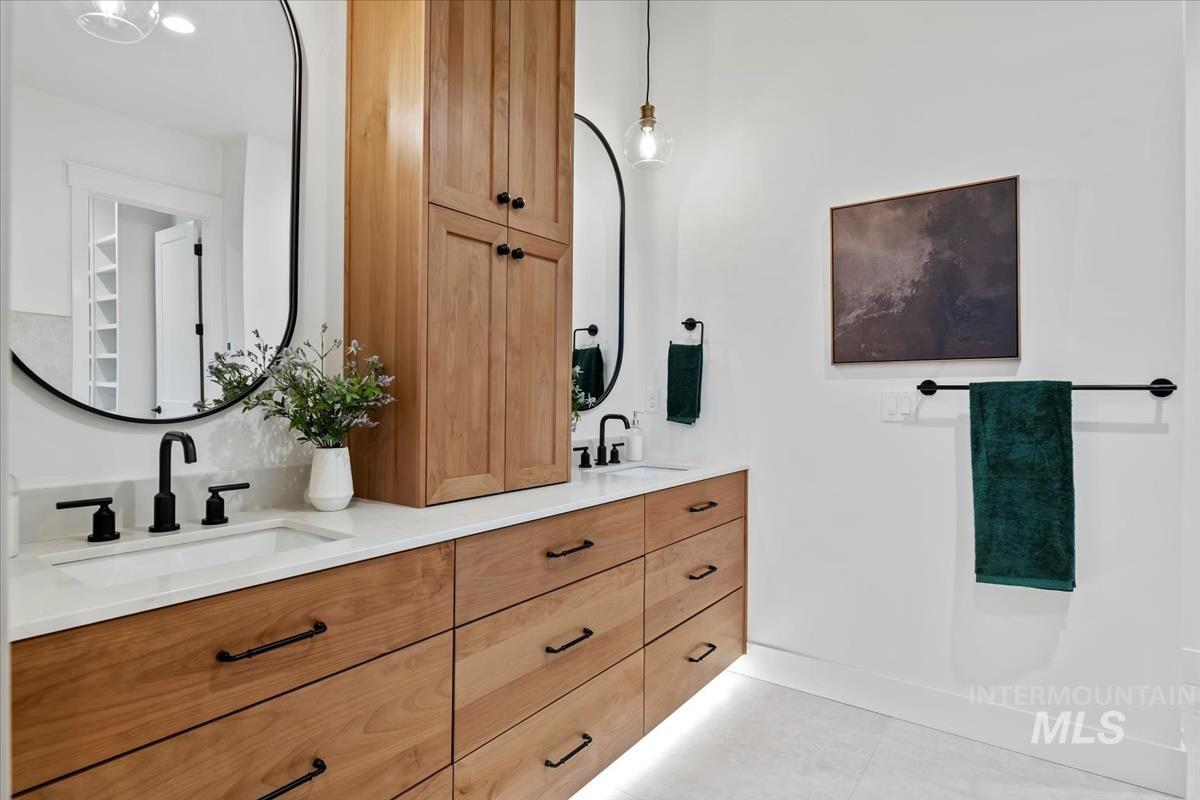 Bathroom with double vanity and light tile patterned flooring