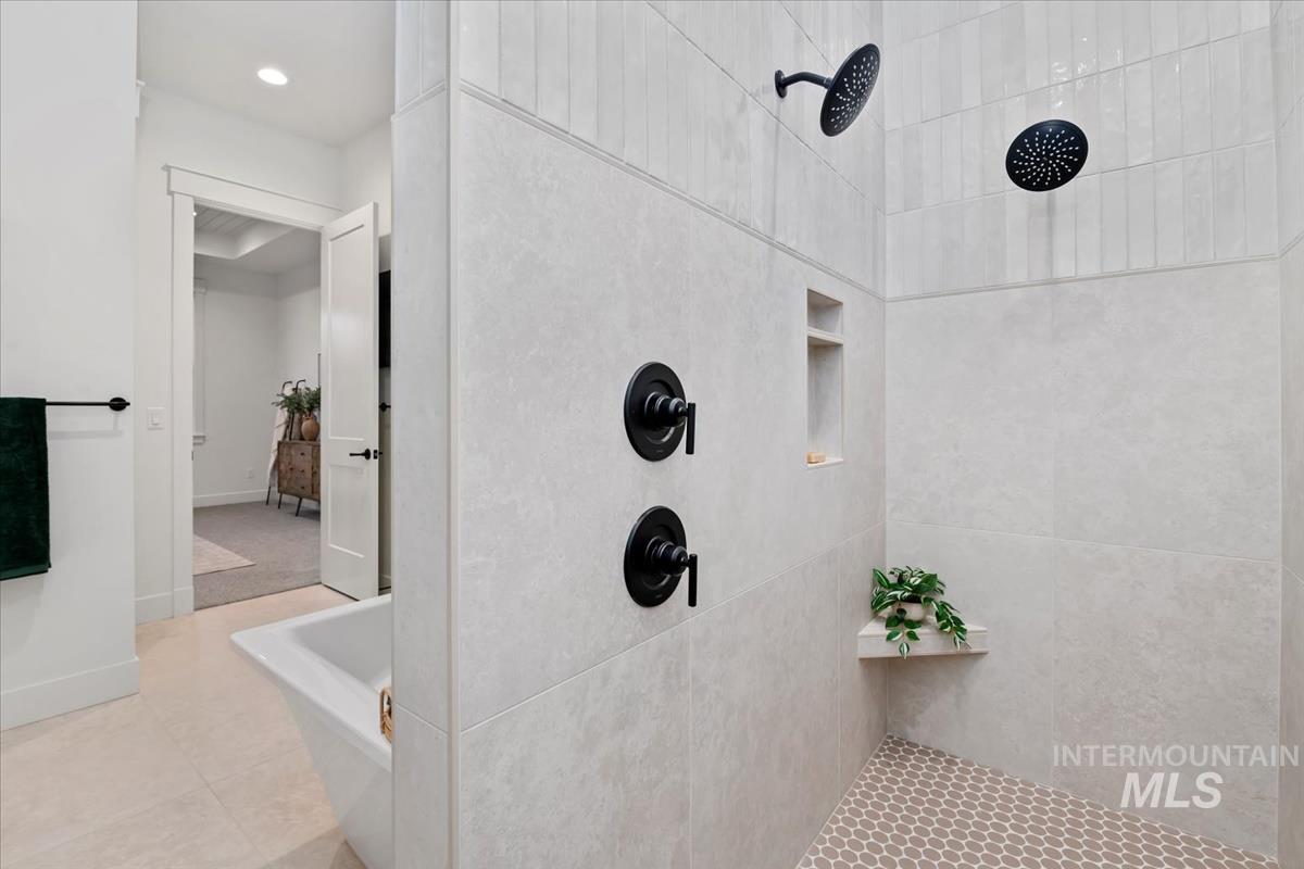 Bathroom featuring tiled shower, recessed lighting, and light tile patterned floors