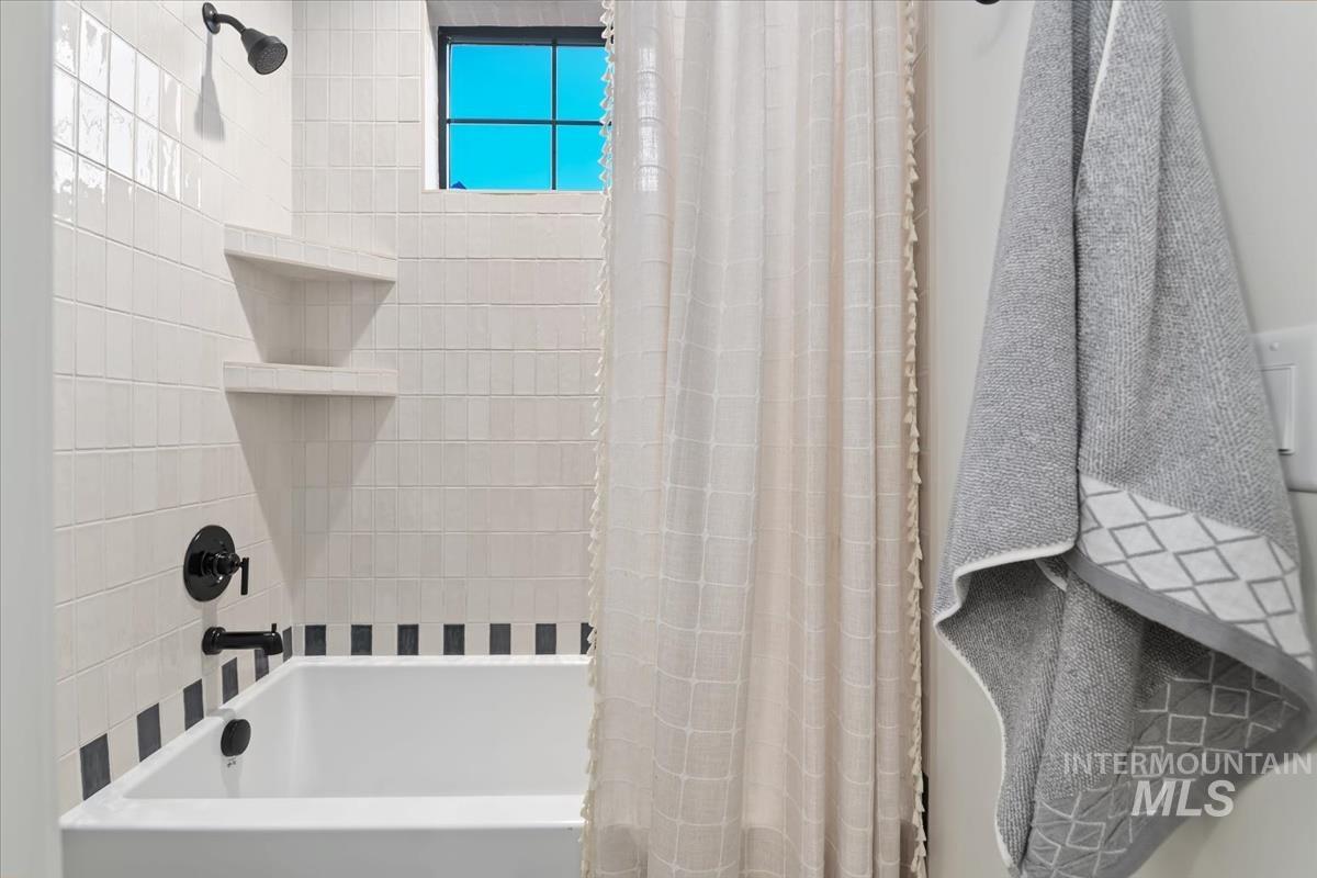 Bathroom featuring shower / bathtub combination with curtain