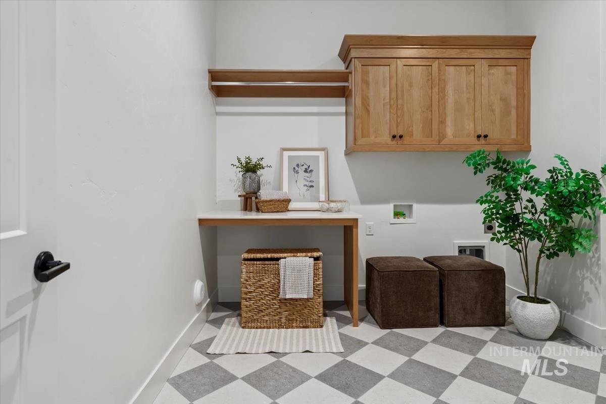 Washroom with light floors, cabinet space, and hookup for a washing machine