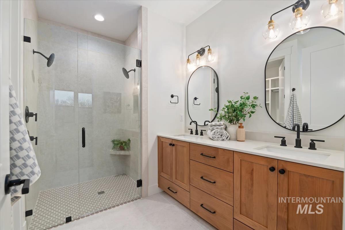 Bathroom with a shower stall, double vanity, light tile patterned flooring, and recessed lighting