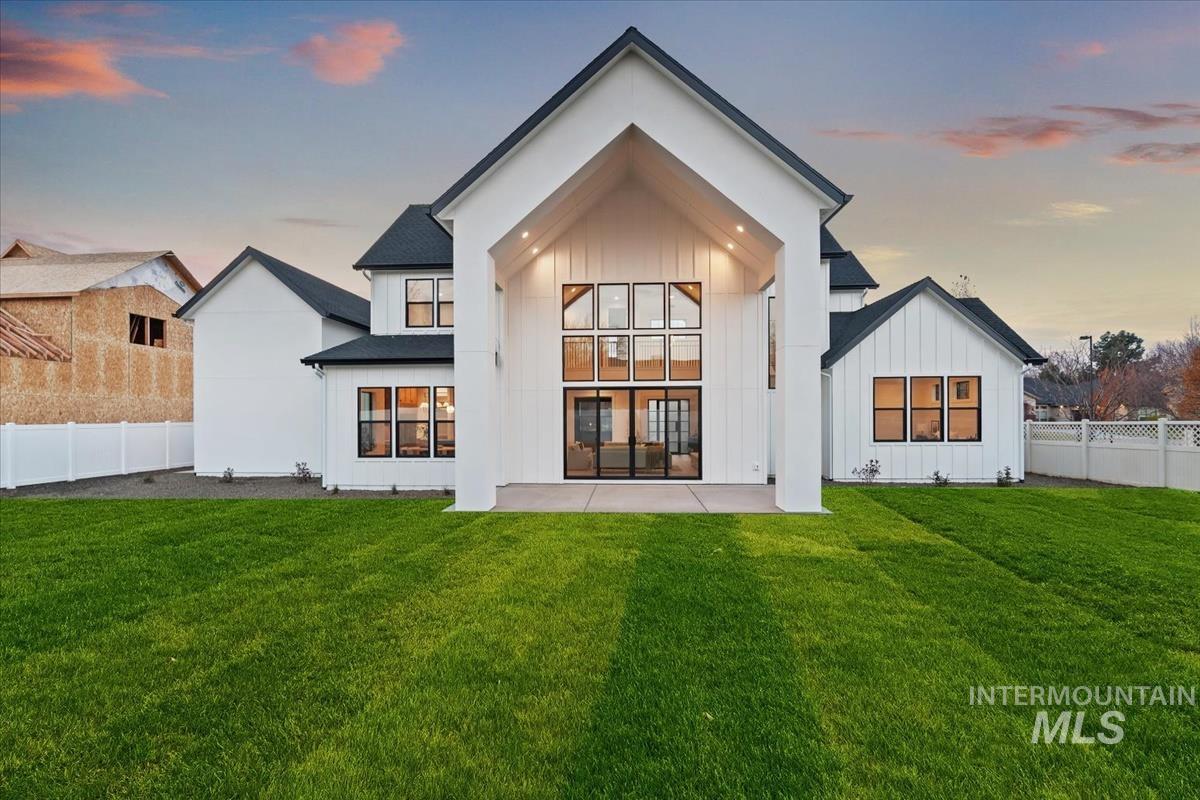 Back of house with a fenced backyard and board and batten siding