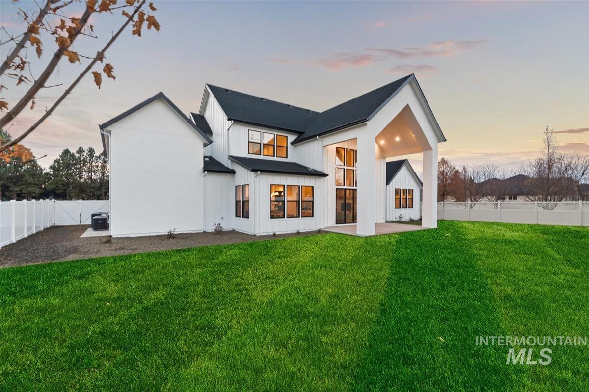 Rear view of house featuring a fenced backyard, board and batten siding, and a patio area