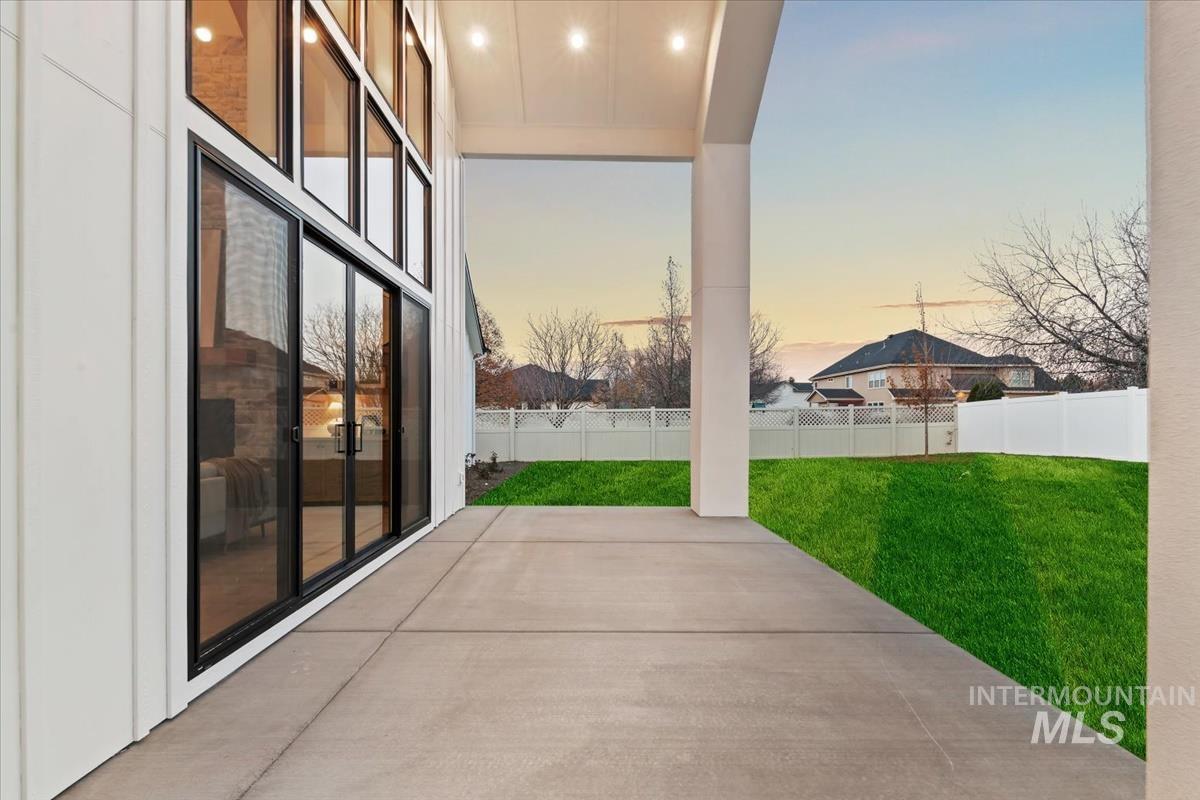 Patio terrace at dusk featuring a patio area and a fenced backyard