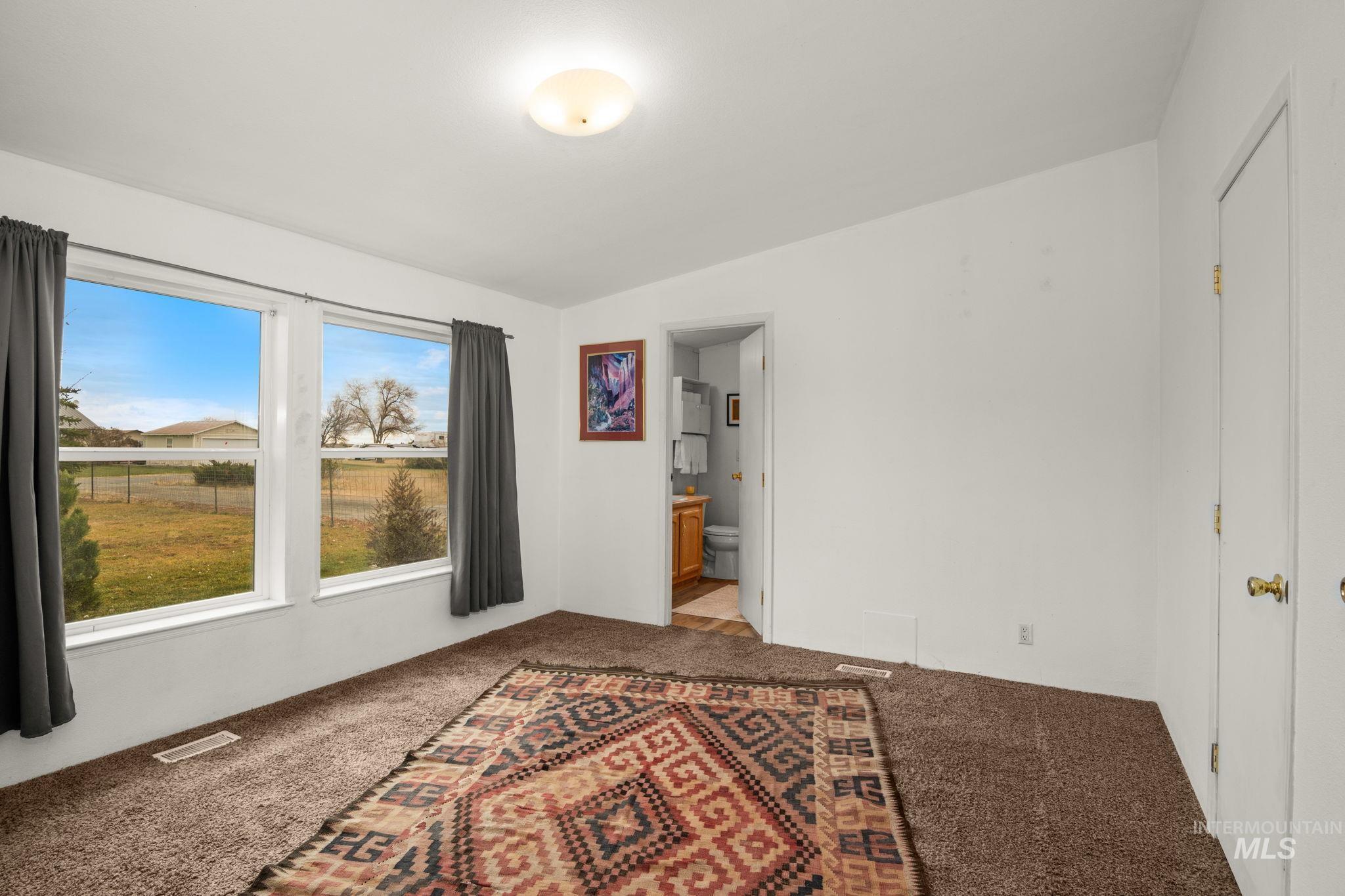 Spare room featuring carpet and vaulted ceiling