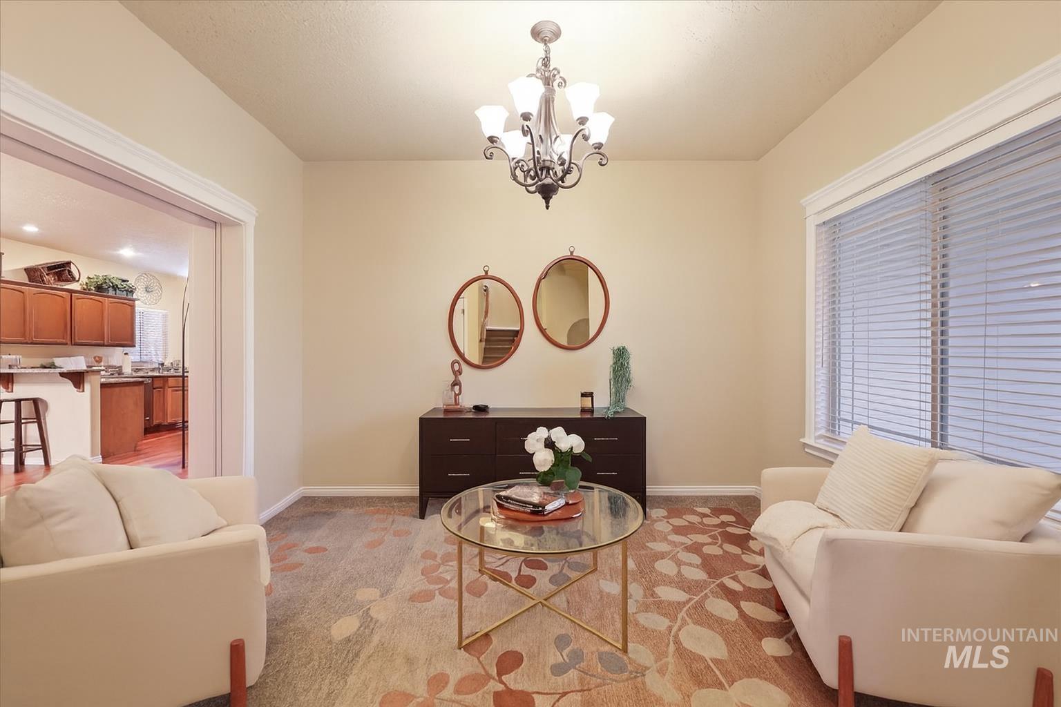 Living area featuring a chandelier and light carpet