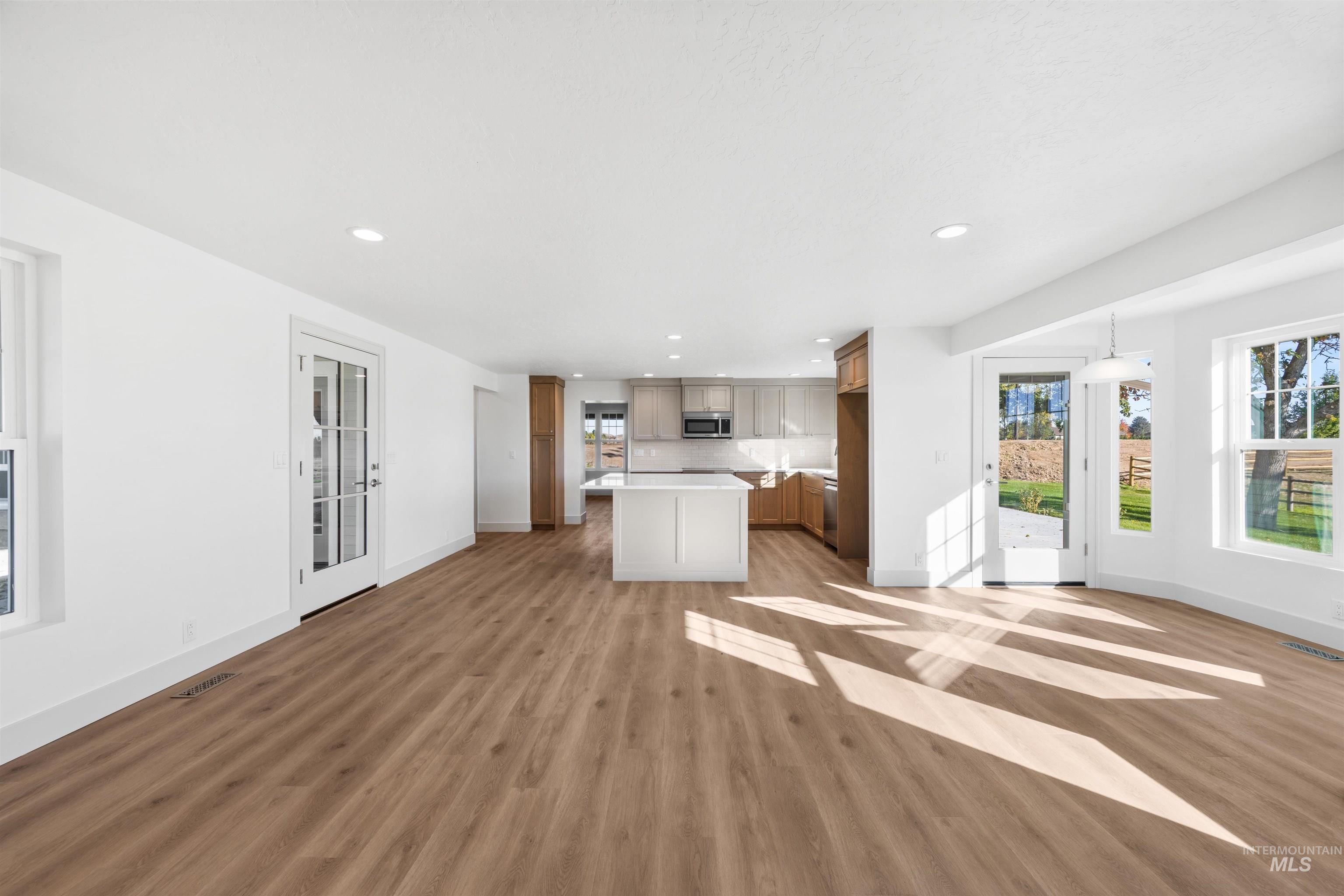 Kitchen featuring open floor plan, healthy amount of natural light, light countertops, recessed lighting, and a kitchen island