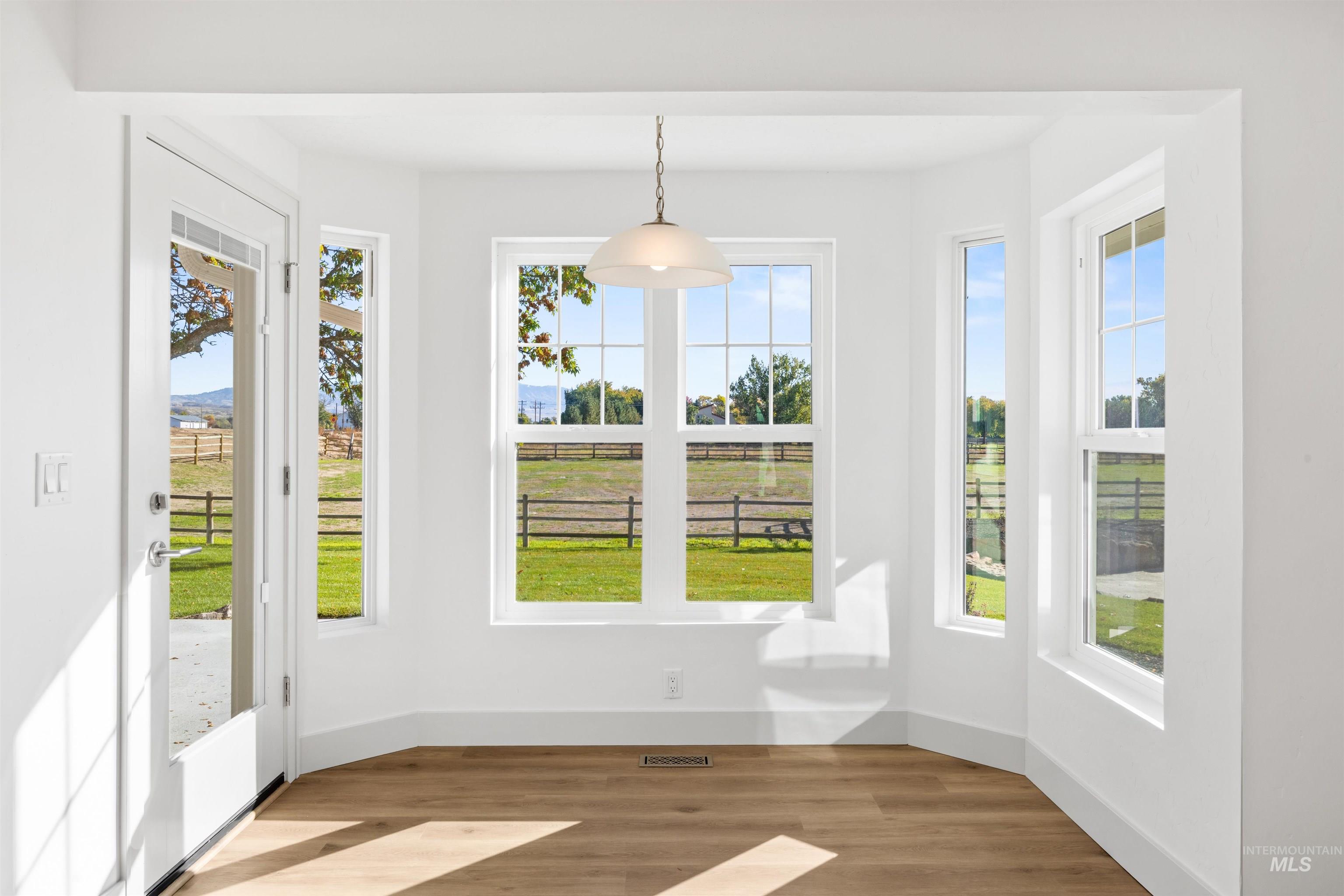 Unfurnished dining area with wood finished floors and baseboards