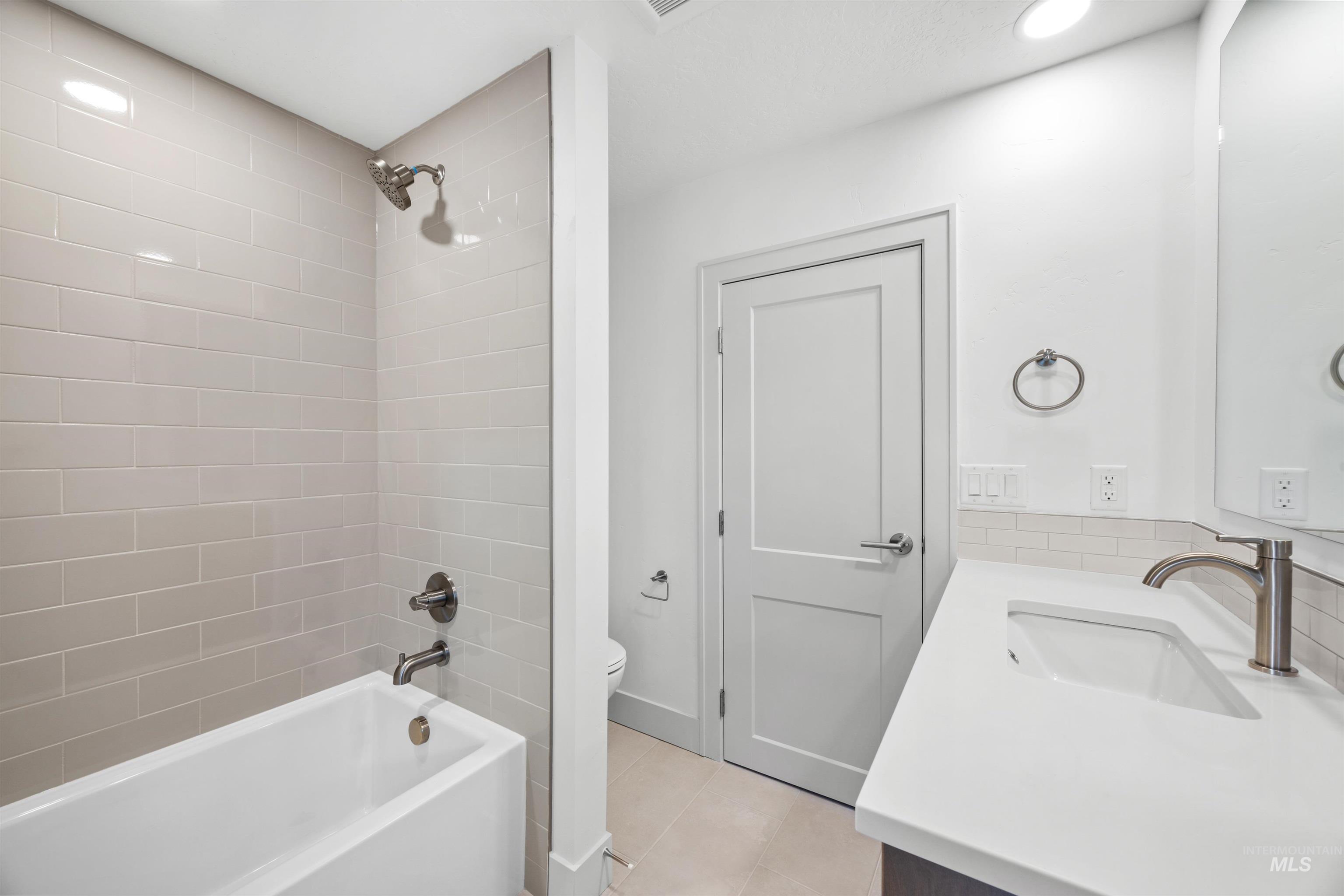 Full bath featuring vanity, bathtub / shower combination, light tile patterned floors, and recessed lighting