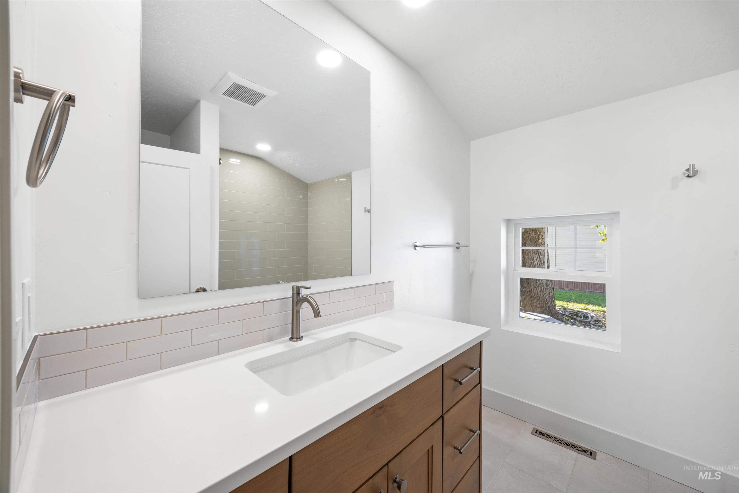 Full bathroom with vanity and light tile patterned floors