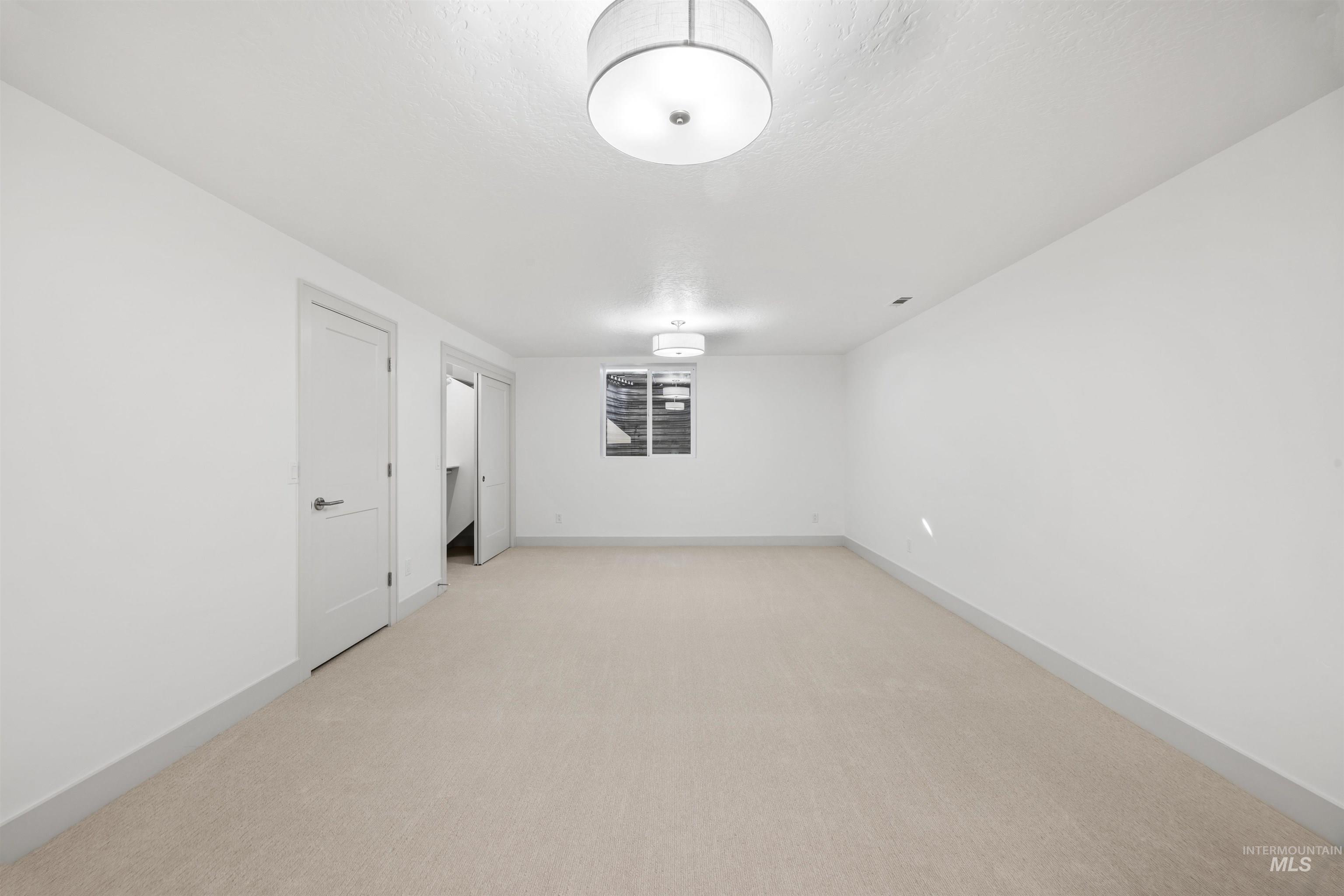 Spare room featuring light carpet and a textured ceiling