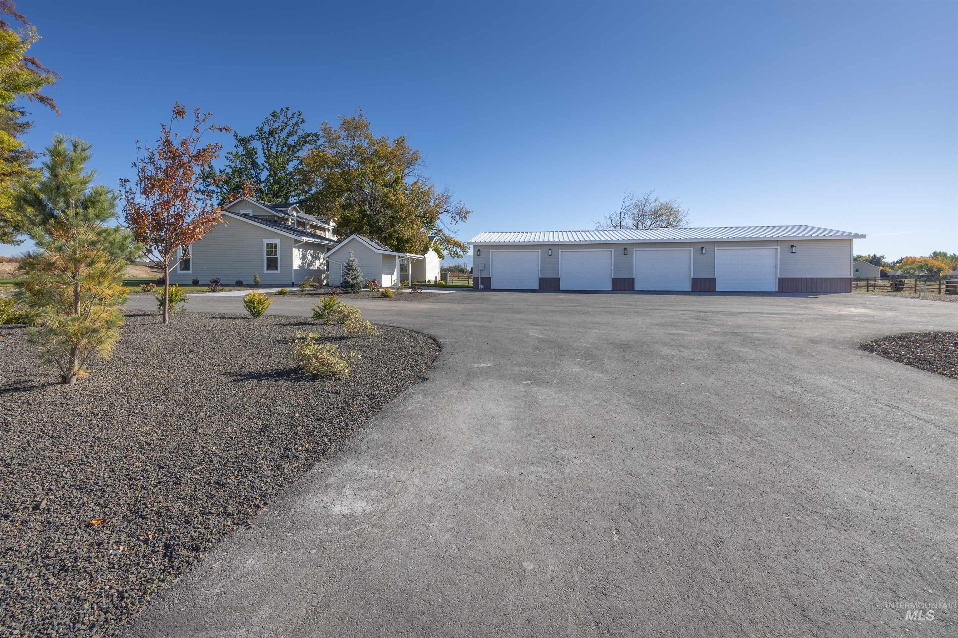 Ranch-style home featuring a garage and an outbuilding