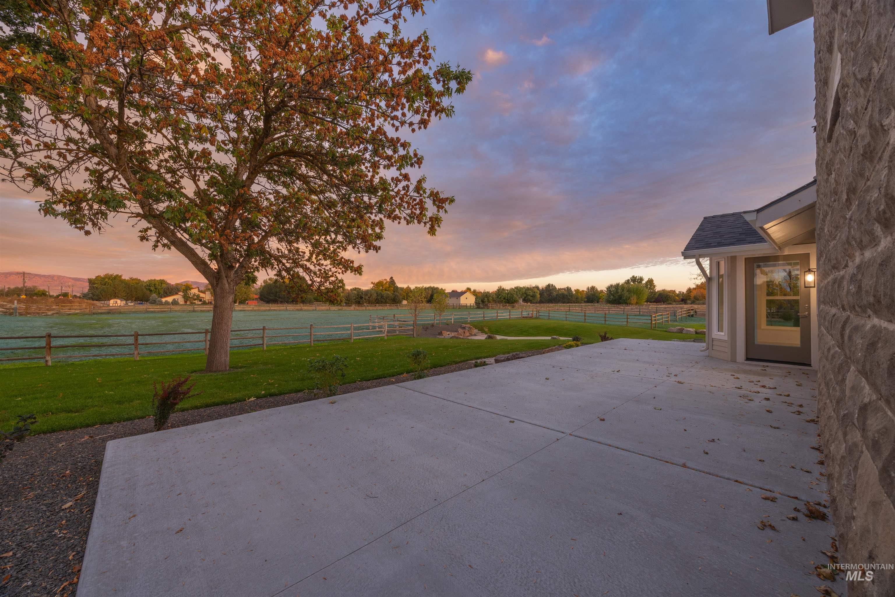 Fenced backyard featuring a patio and a rural view