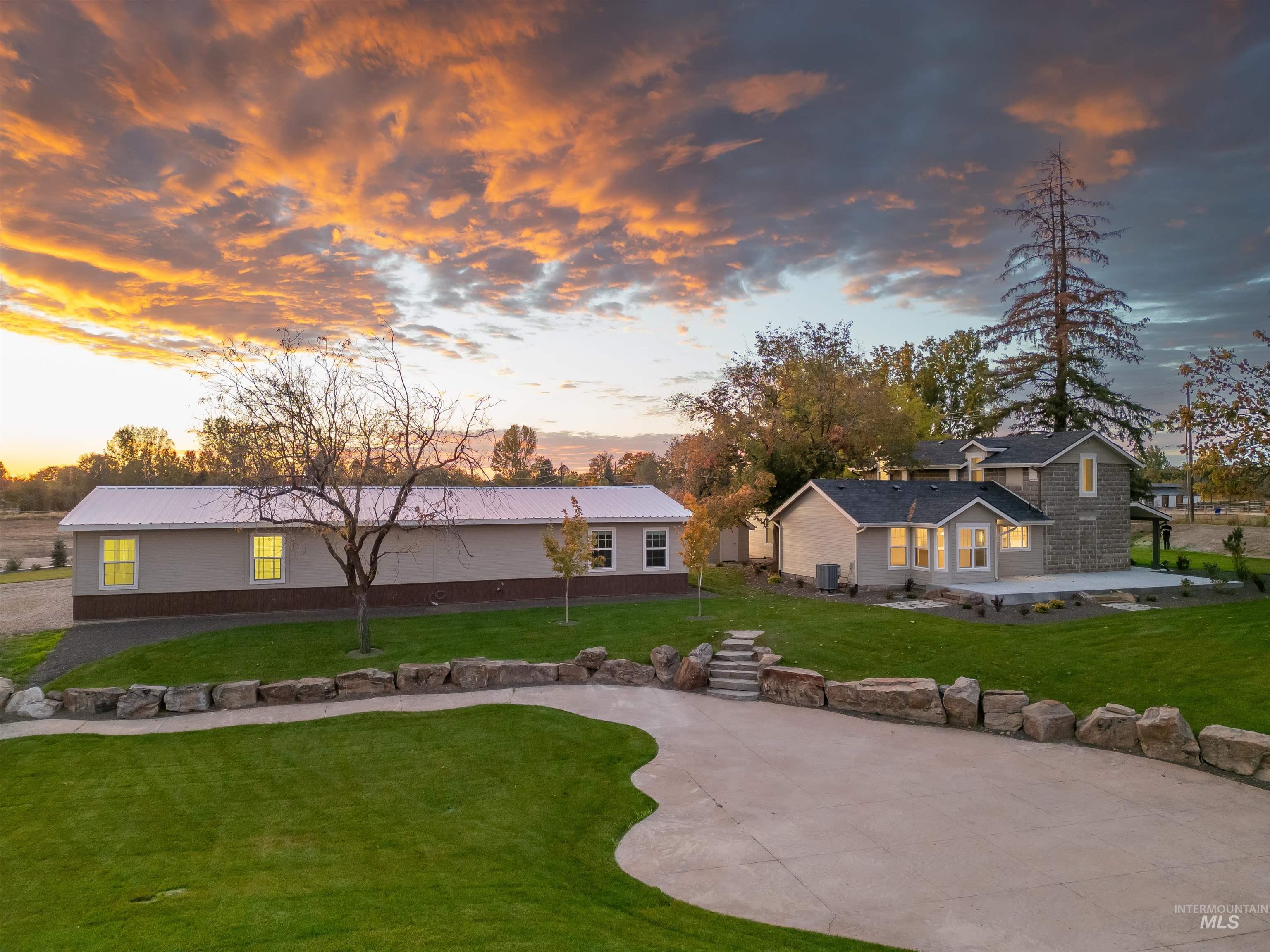 Back of property at dusk featuring a yard, a metal roof, and a patio