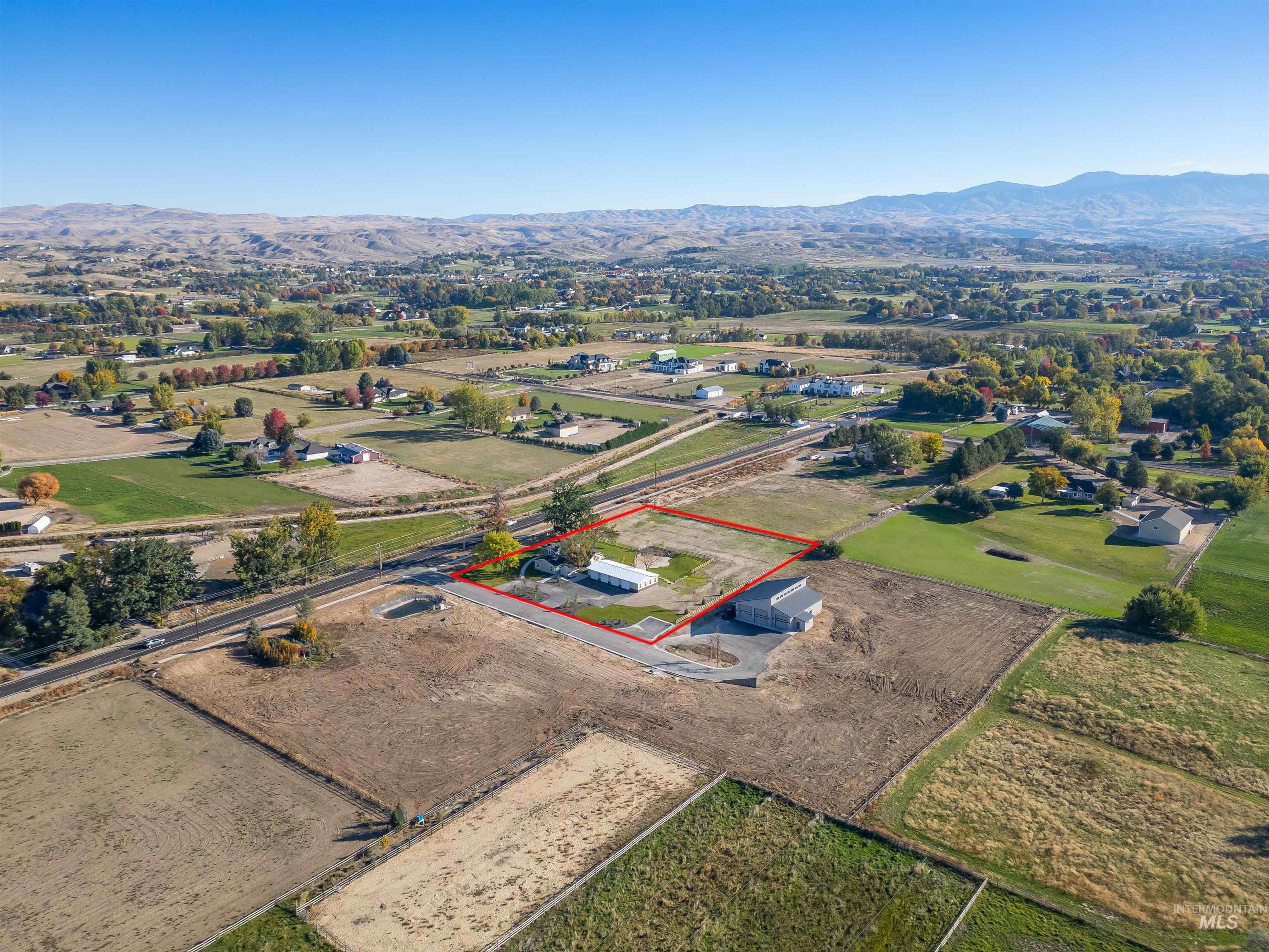 Overview of rural landscape with a mountain backdrop and property parcel outlined