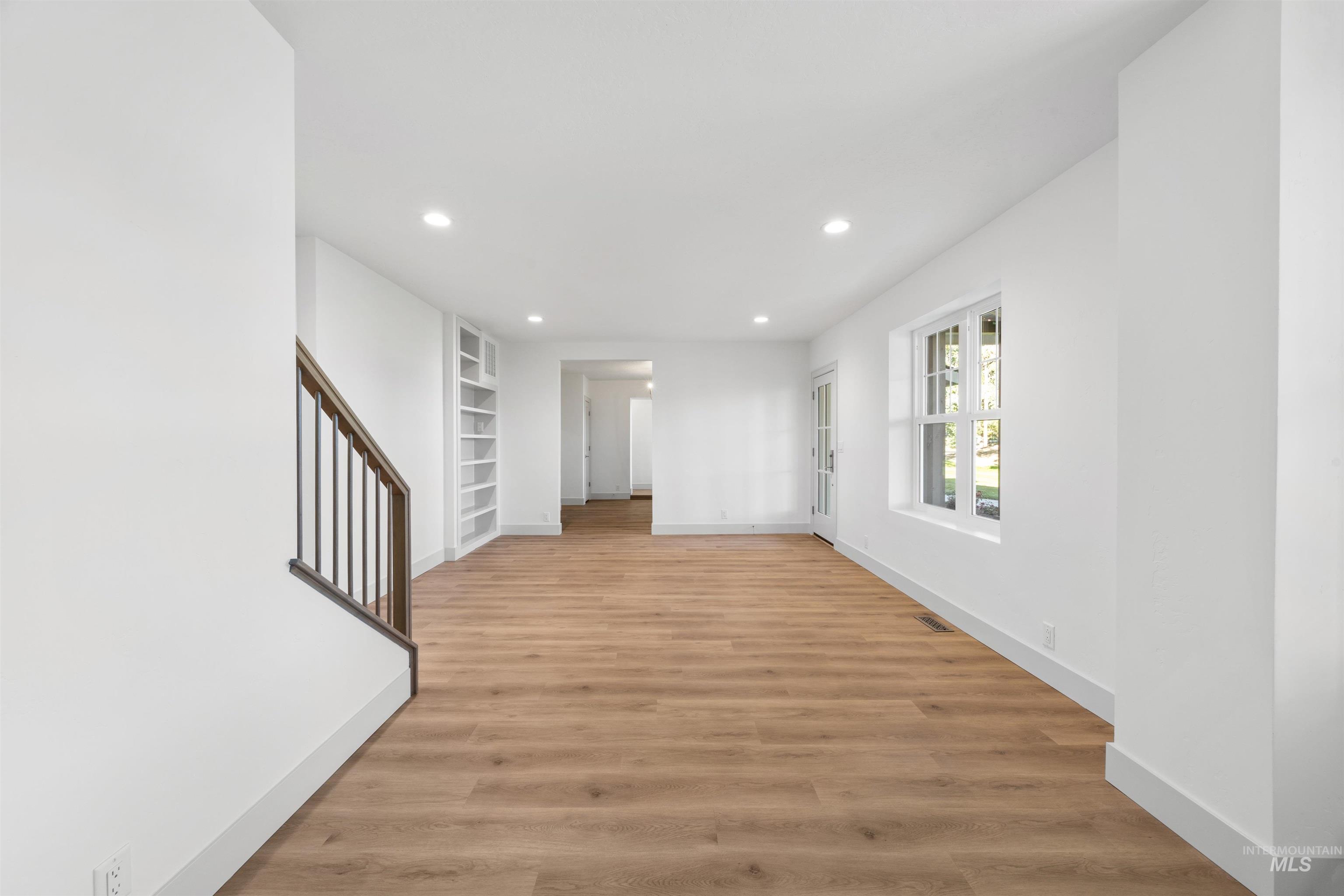 Unfurnished room featuring recessed lighting, light wood-style flooring, and built in shelves