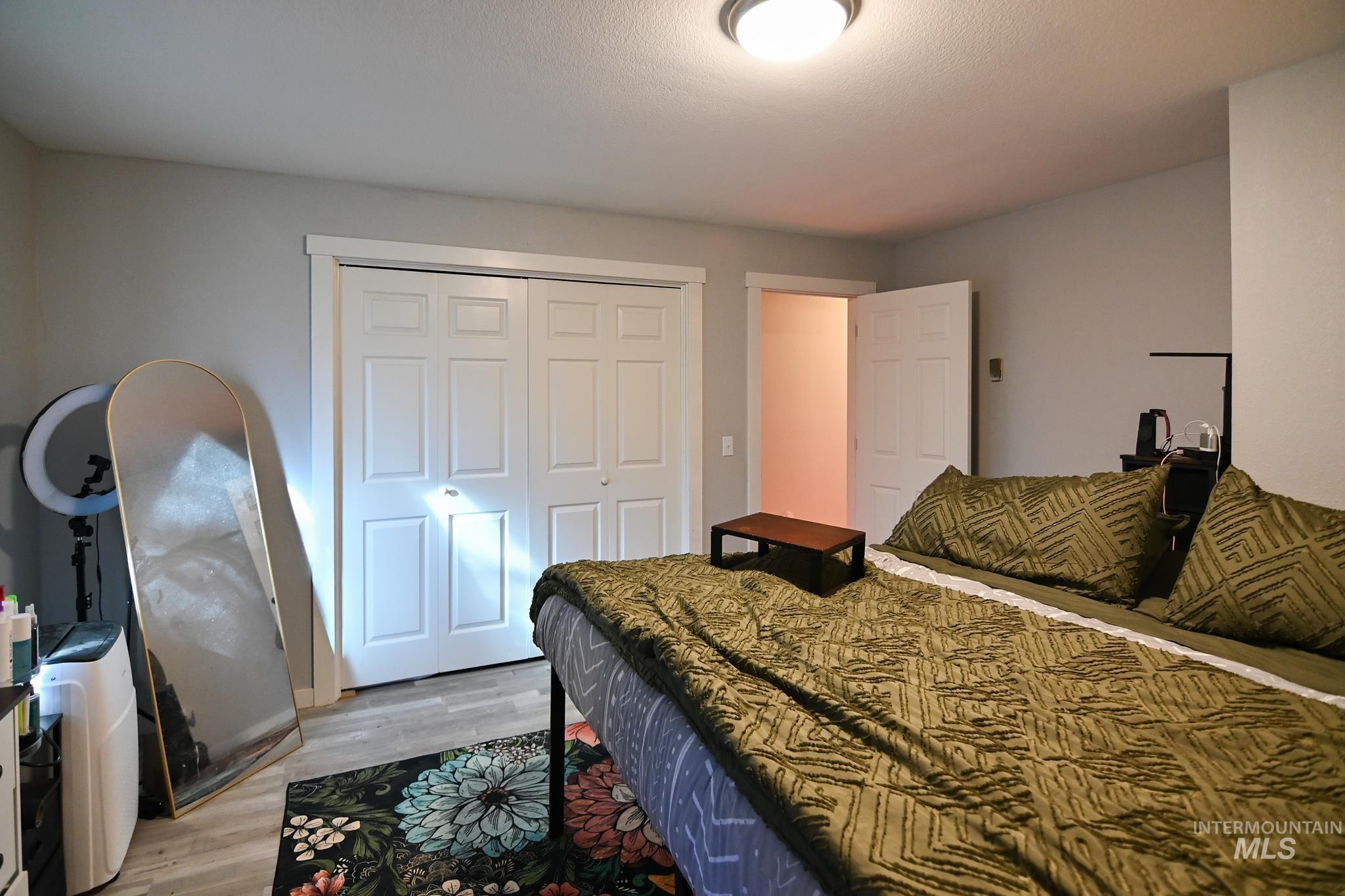 Bedroom with light wood-style flooring and a closet