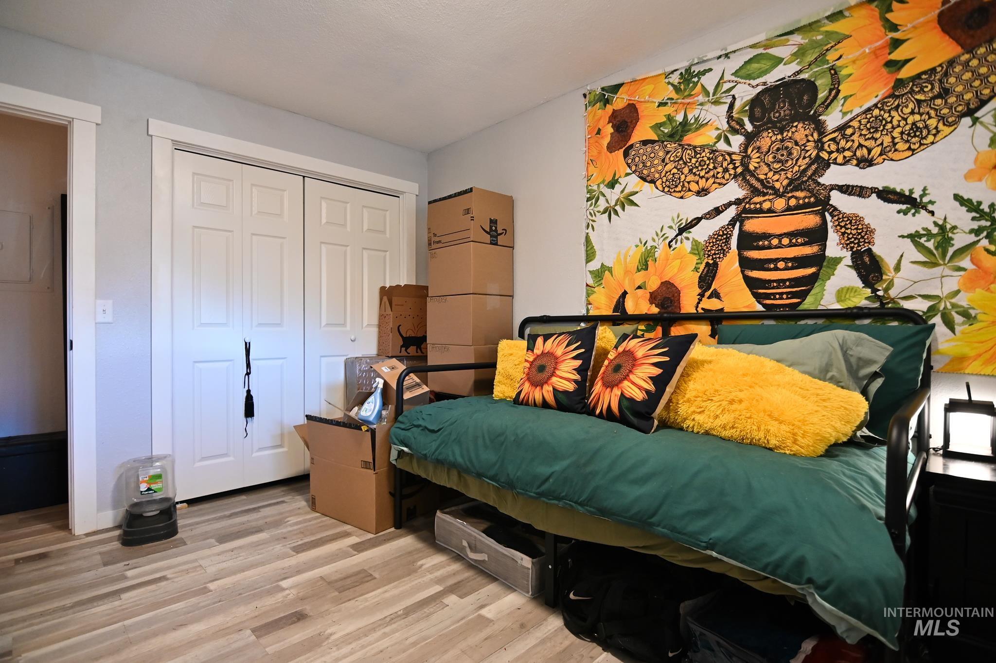 Bedroom featuring light wood-style floors and a closet