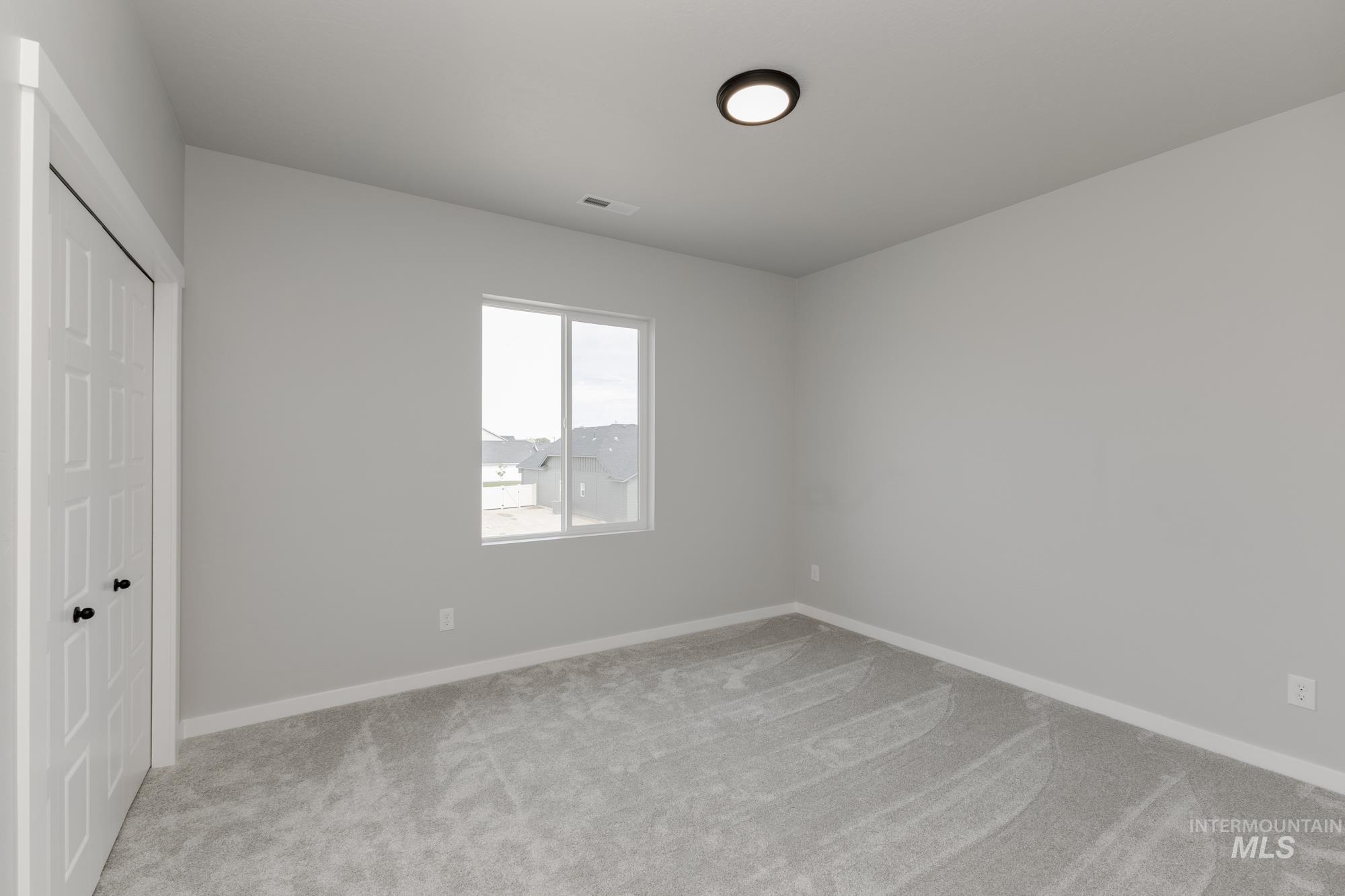Unfurnished bedroom with light colored carpet and a closet