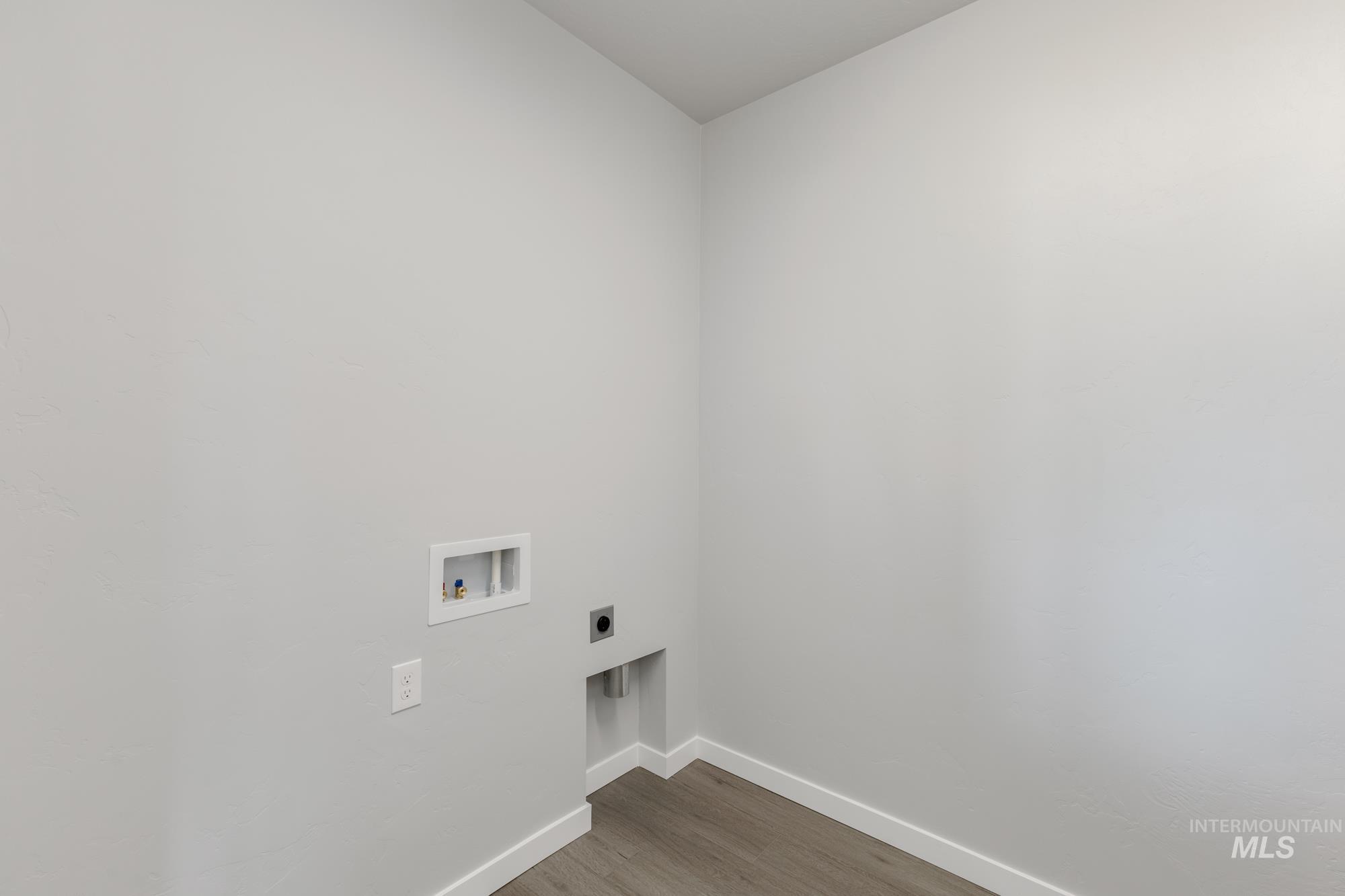 Washroom with wood finished floors, hookup for a washing machine, and hookup for an electric dryer