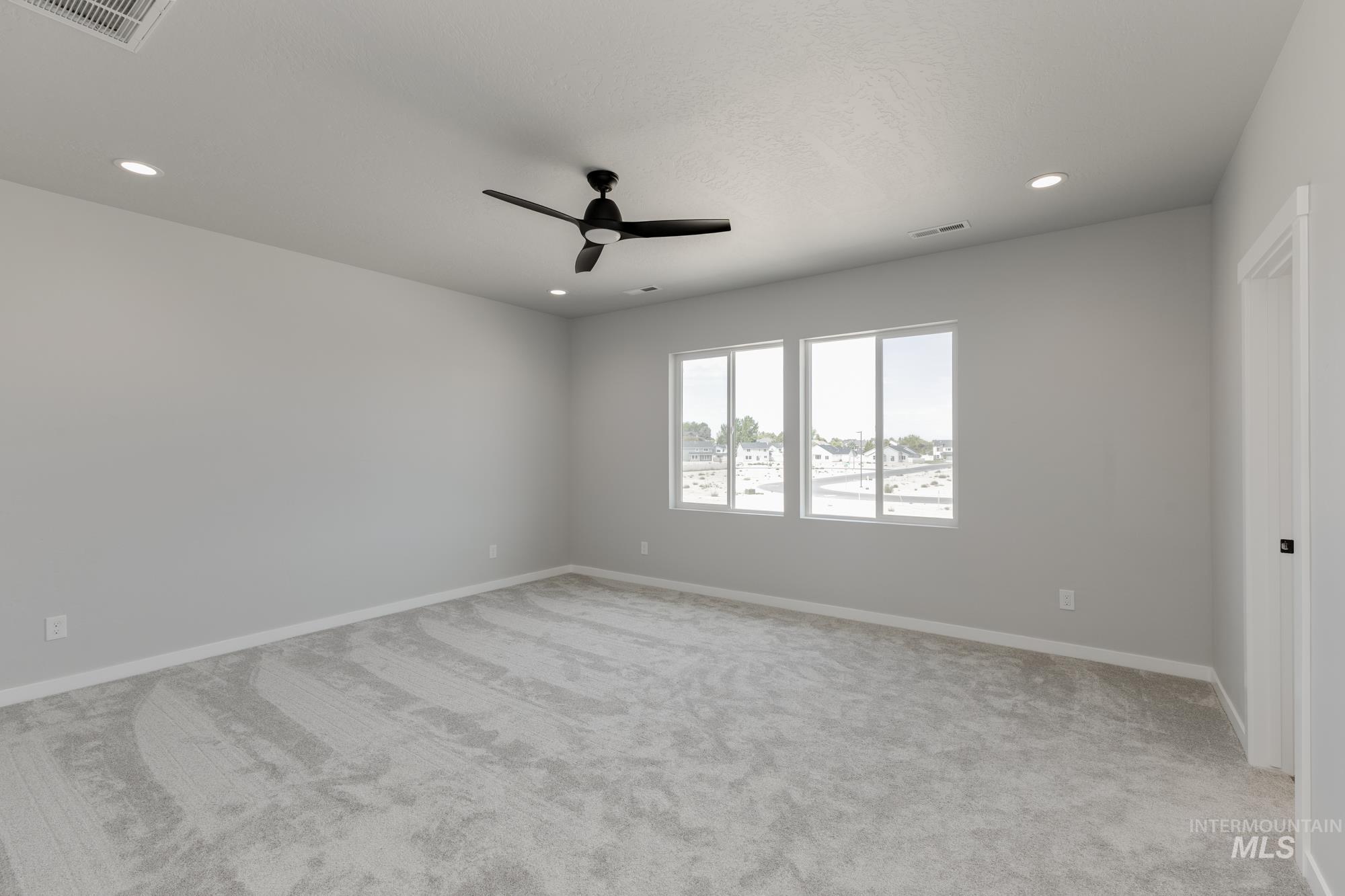 Empty room featuring light carpet, a ceiling fan, and recessed lighting