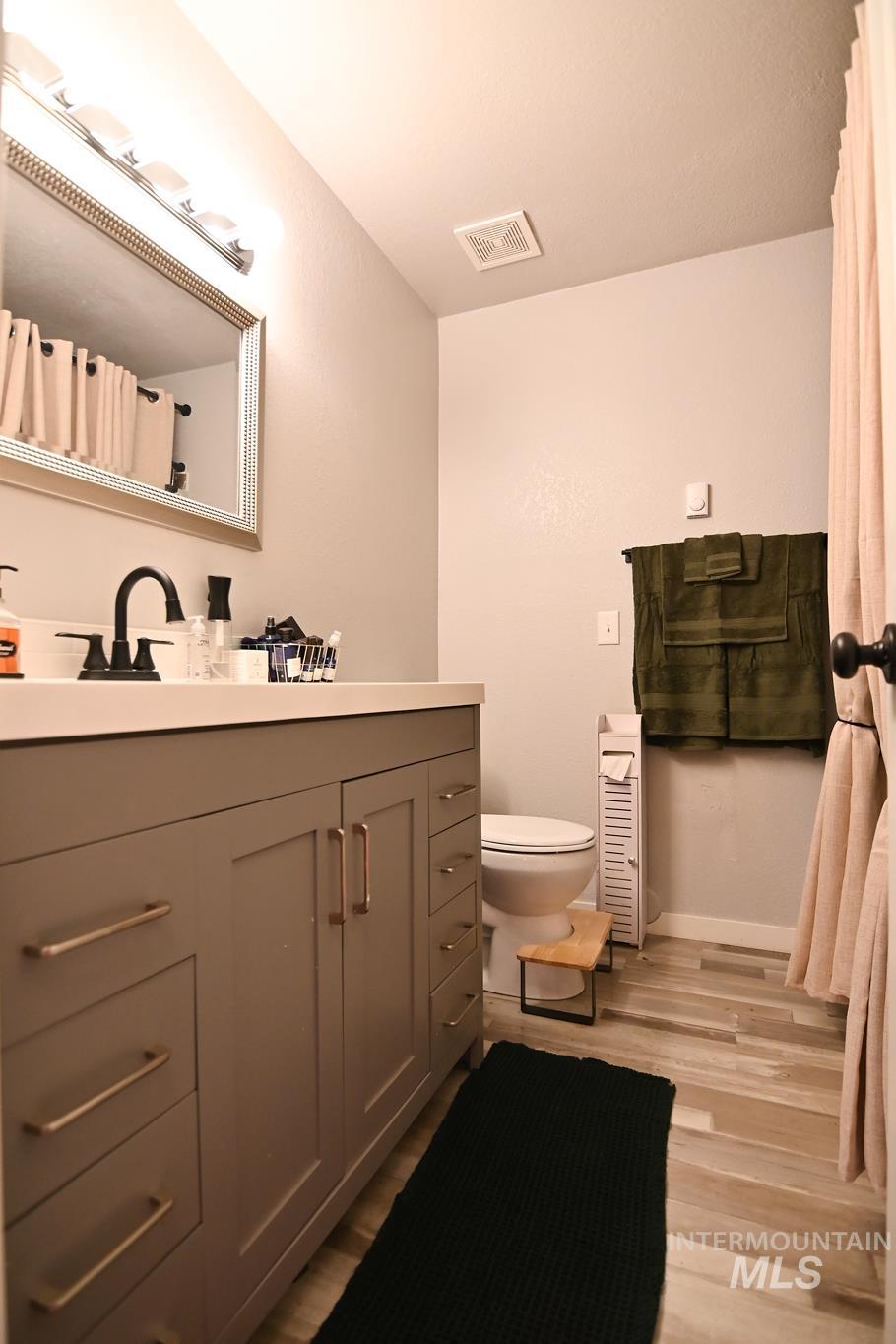 Bathroom featuring vanity, light wood-style floors, and a shower with shower curtain
