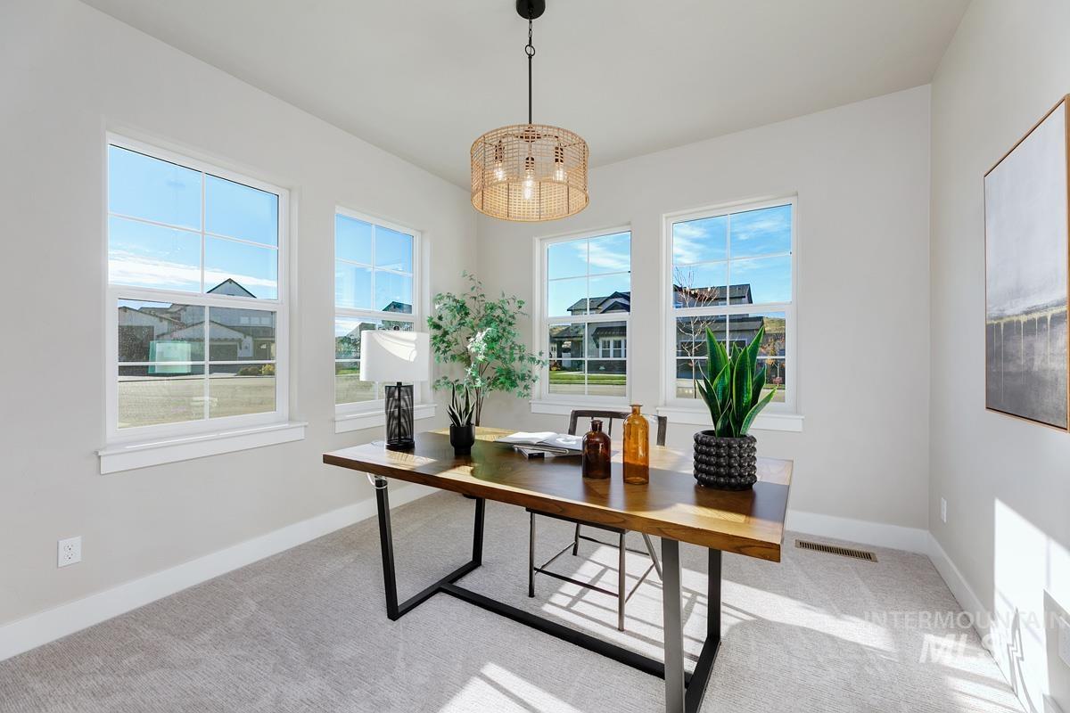 Office space featuring light colored carpet and a chandelier
