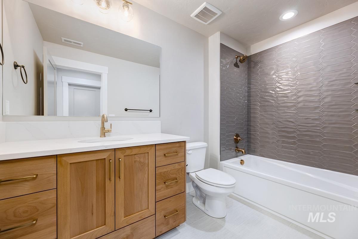 Full bath with shower / bath combination, vanity, and light tile patterned flooring